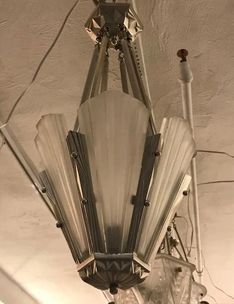 Lampadario Artistics francese firmato dal famoso artista Degué. Ha sei pannelli in vetro trasparente smerigliato con dettagli a motivi geometrici. Dettagli lucidi su una cornice dal design geometrico in nichel. È stato ricablato per l'uso americano
