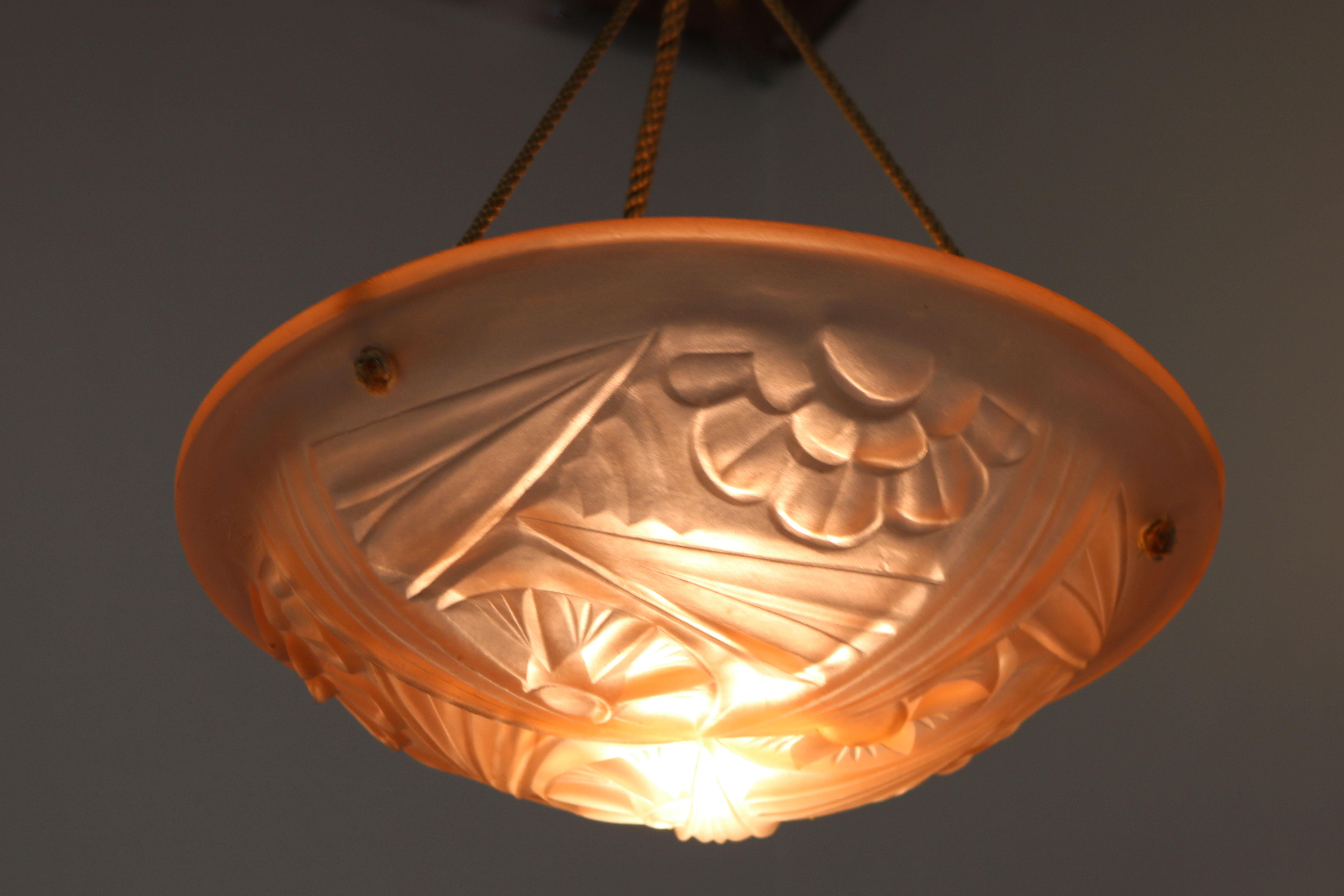 Gorgeous solid glass Art Deco chandelier from France 1930 singed by Degue
The chandelier is fully original with its antique rope suspension 
The frosted glass shade has a light pink colour with various Art Deco motives , looks amazing when lit.