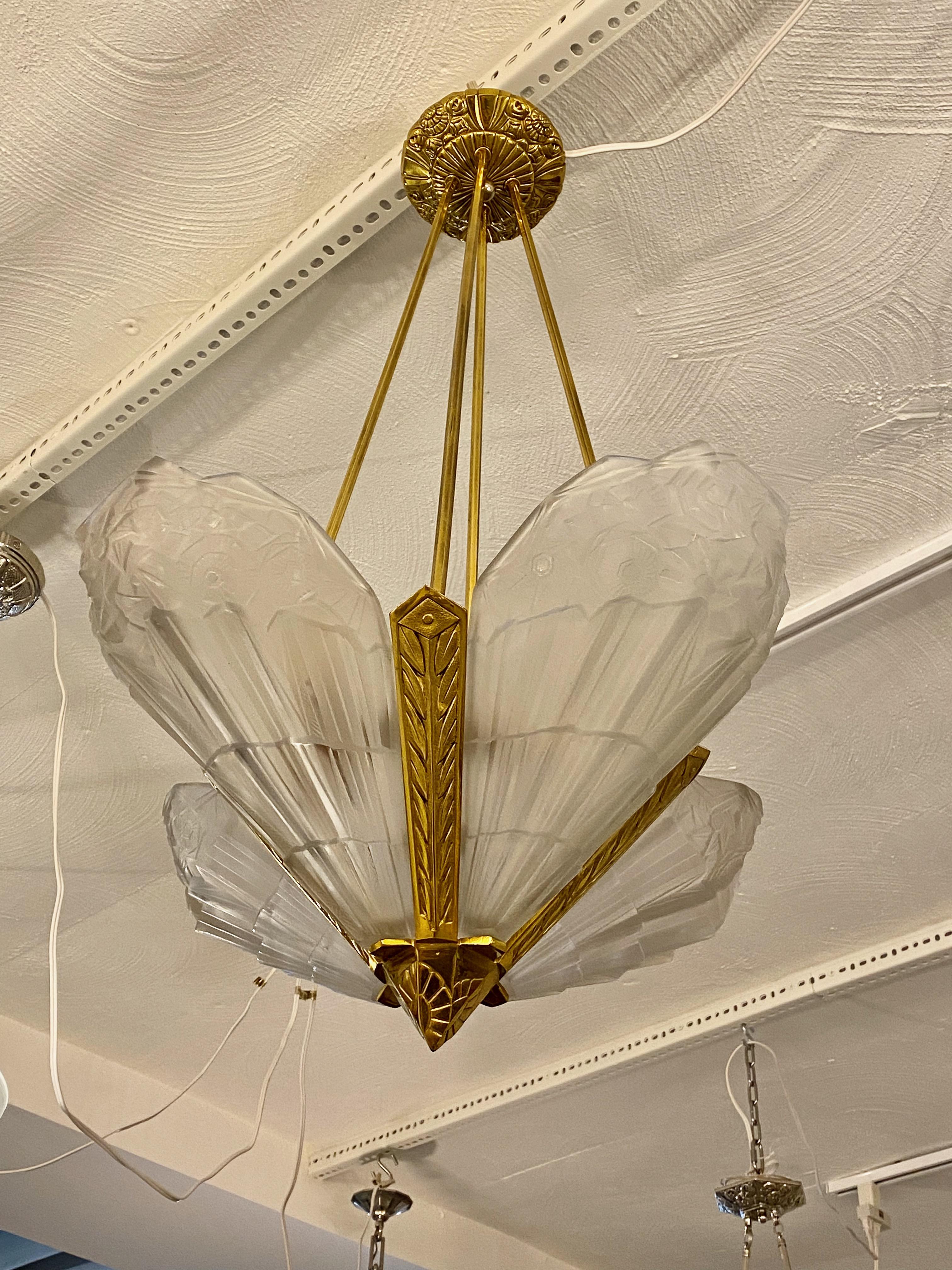 French Art Deco chandelier signed by the French artist J. Robert. Four glass panels with geometric and floral design. Rest in a matching brass frame having geometric and floral design throughout. Has been rewired for American use with four