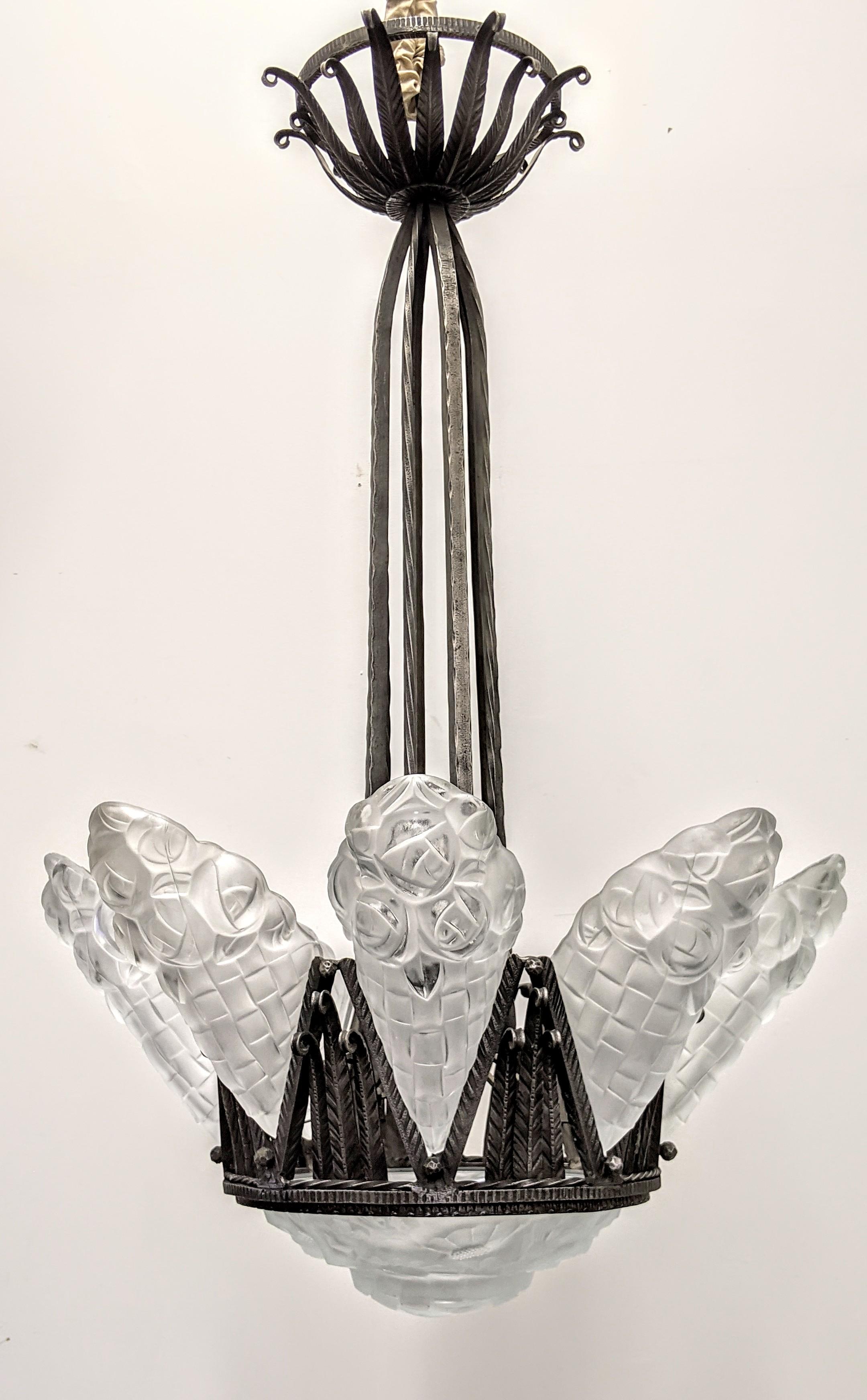 A French Art Deco chandelier with eight-side shades embracing a matching center round coupe in clear frosted molded shades. Each side shade including the center coupe is signed by the French artist Degué (signature in the last two images). Flower