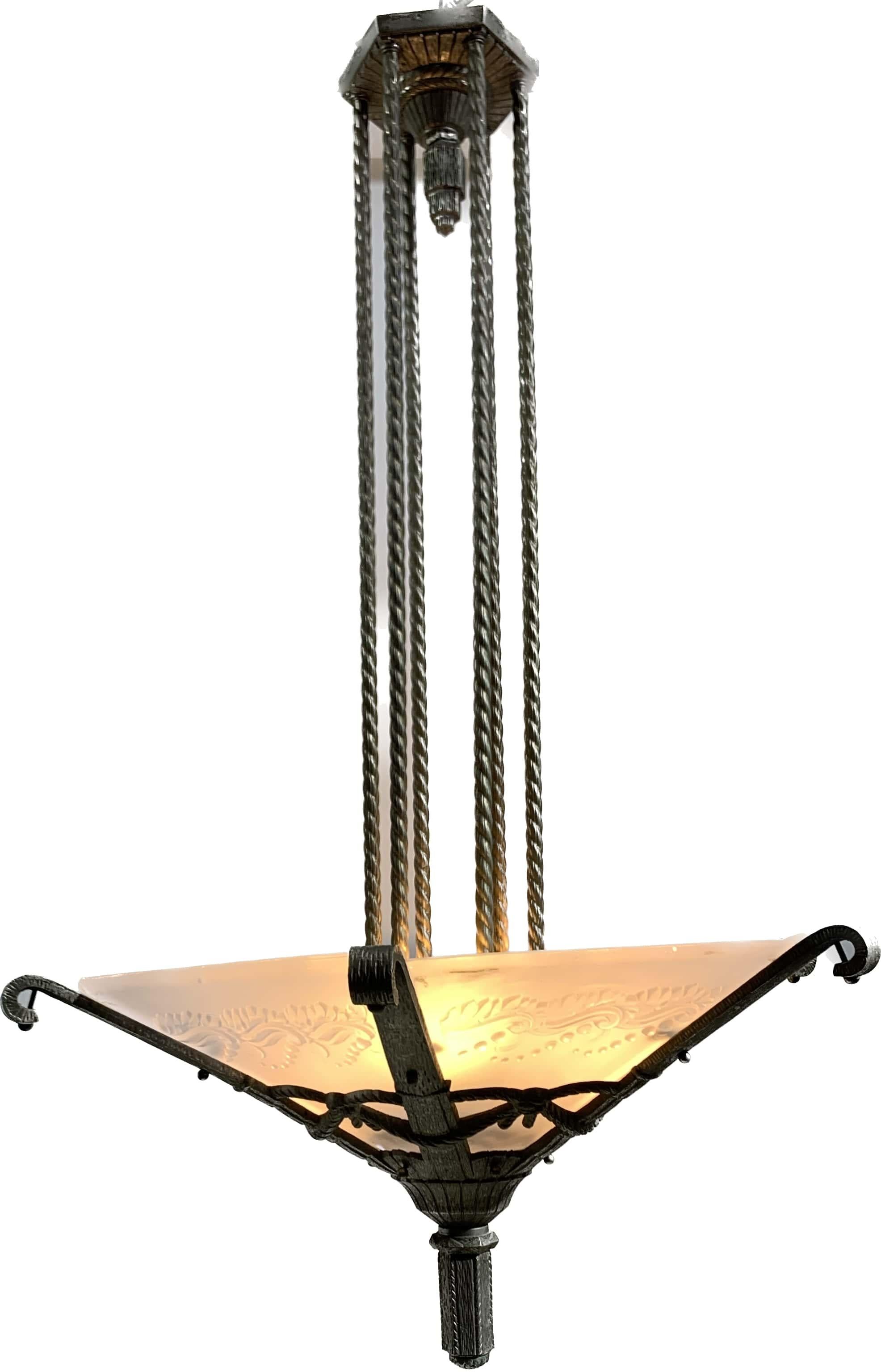 Araña francesa Art Déco de estructura de bronce retorcido con grabados detallados, que sostiene una guirnalda en la parte inferior. Tiene seis pantallas de vidrio arenado prensado modulado que representan diseños inspirados en la naturaleza. Las