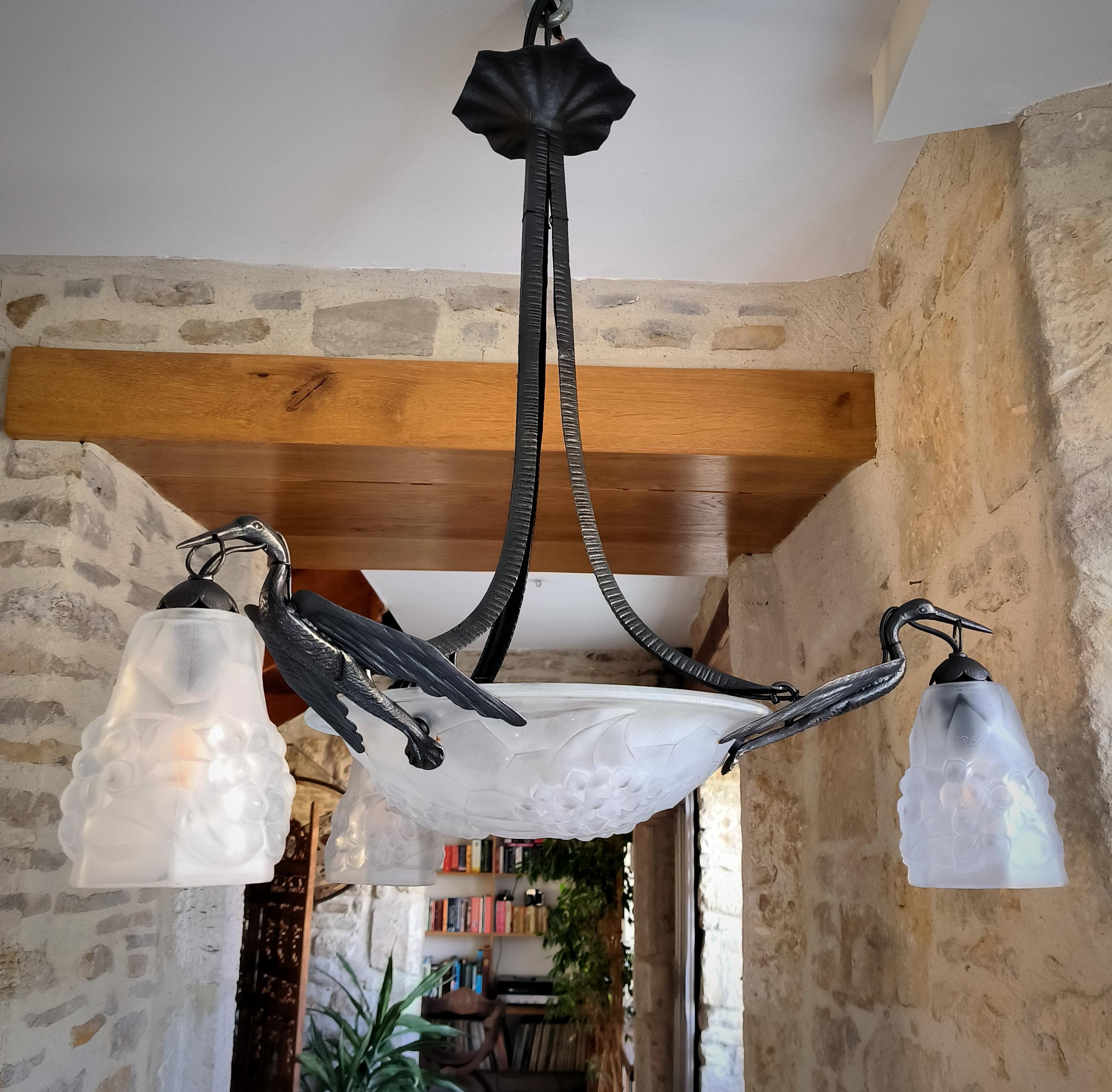 Magnífico candelabro colgante de hierro forjado y cristal, antiguo, Art Decó, francés por excelencia, con 3 cigüeñas en vuelo, firmado Ros, por Degué, hacia 1930, con su cristalería esmerilada, moldeada, original y firmada.
En general, la araña está