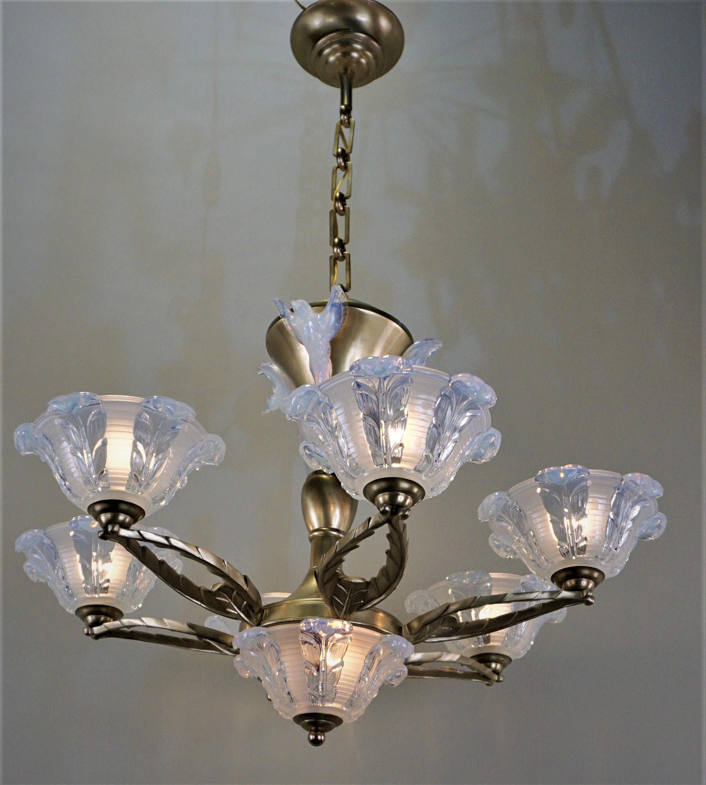 Masterfully crafted in France by noted designer Ezan & Petitot. This Art Deco chandelier is truly elegant. Made of satin finish bronze, this six-arm chandelier features beautiful opaline glass and a total of nine lights.

   