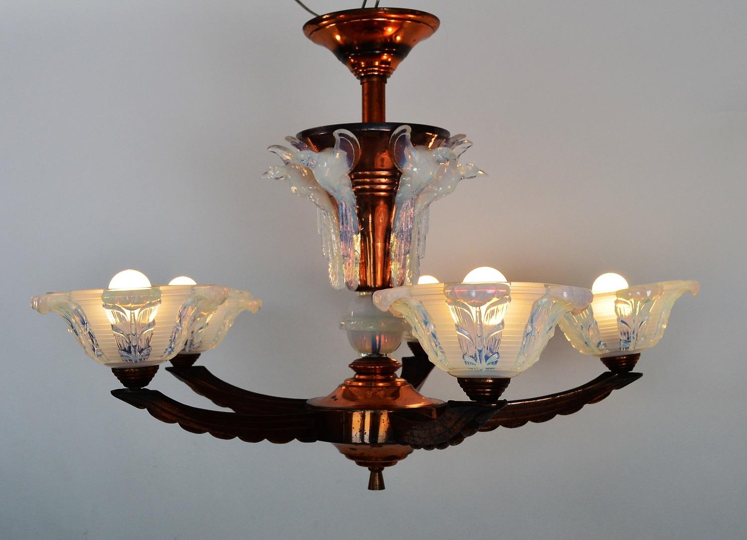 Magnificent French five-arm chandelier made of copper with stunning opalescent glasses.
Produced from Ezan in the 1930s, France.
The chandelier has opalescent flying bird figurines around the upper part and light holder bowls mounted at the five