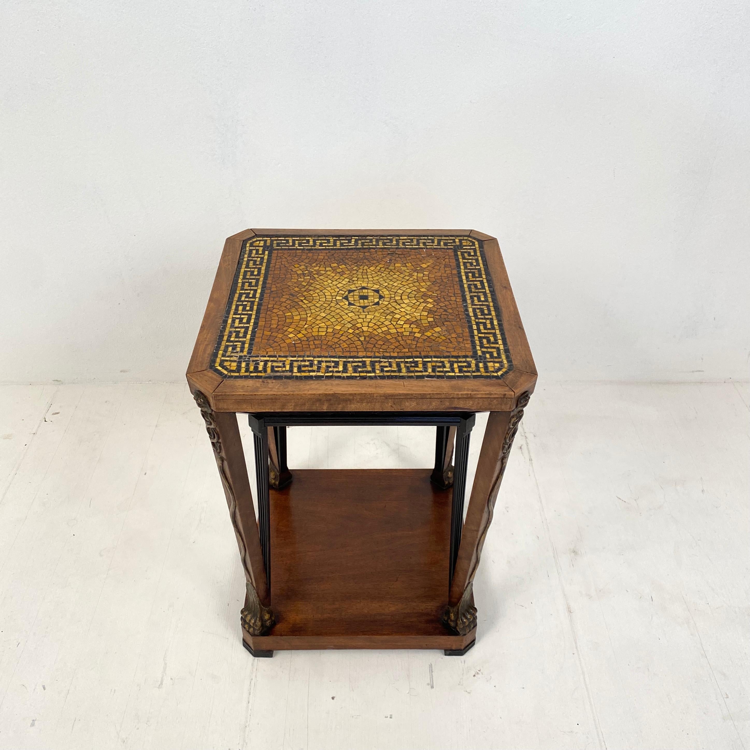 This fantastic French Art Deco Chemist side table made around 1920.
It hast got a gold and black glass tiles mosaic top and a mahogany base with gilded lion feet and the typical rod of Asclepius.
There is also on each leg a carved and gilded