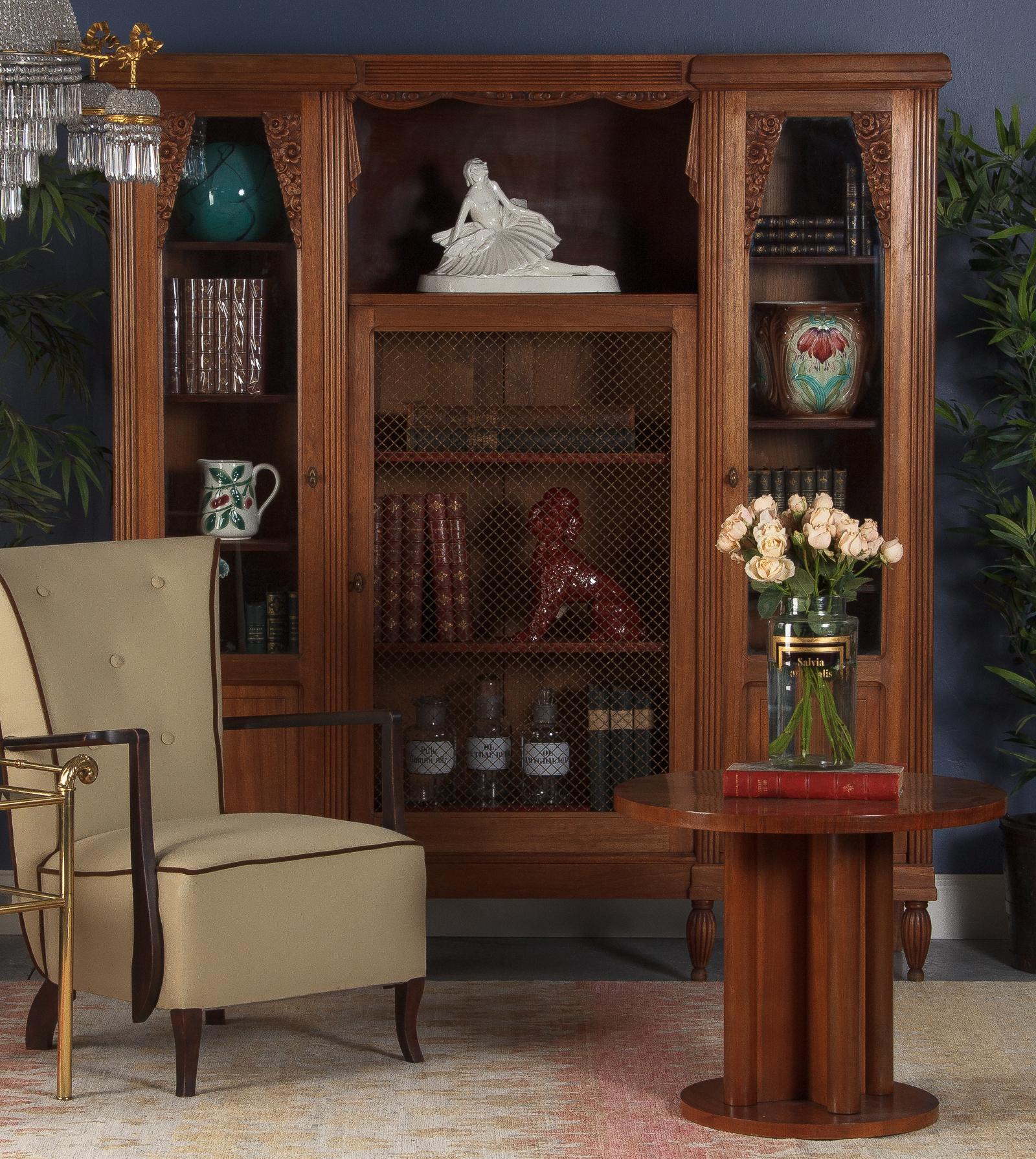 A stunning 3-door French bookcase from the Art Deco period in cherrywood. The sides feature paneled door with original glass and floral motifs at tops. Inside are 4 adjustable shelves 13.75