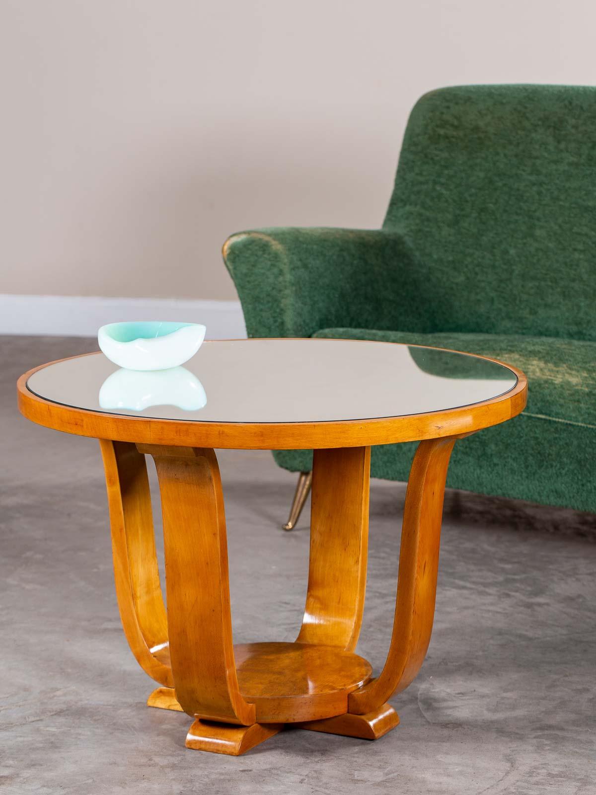 This circular French Art Deco cherrywood table circa 1935 has four sensuously curved legs joining the round top to a raised circular base elevated with four feet. Please enlarge the photographs to see the beauty of the timber as well as the cabinet