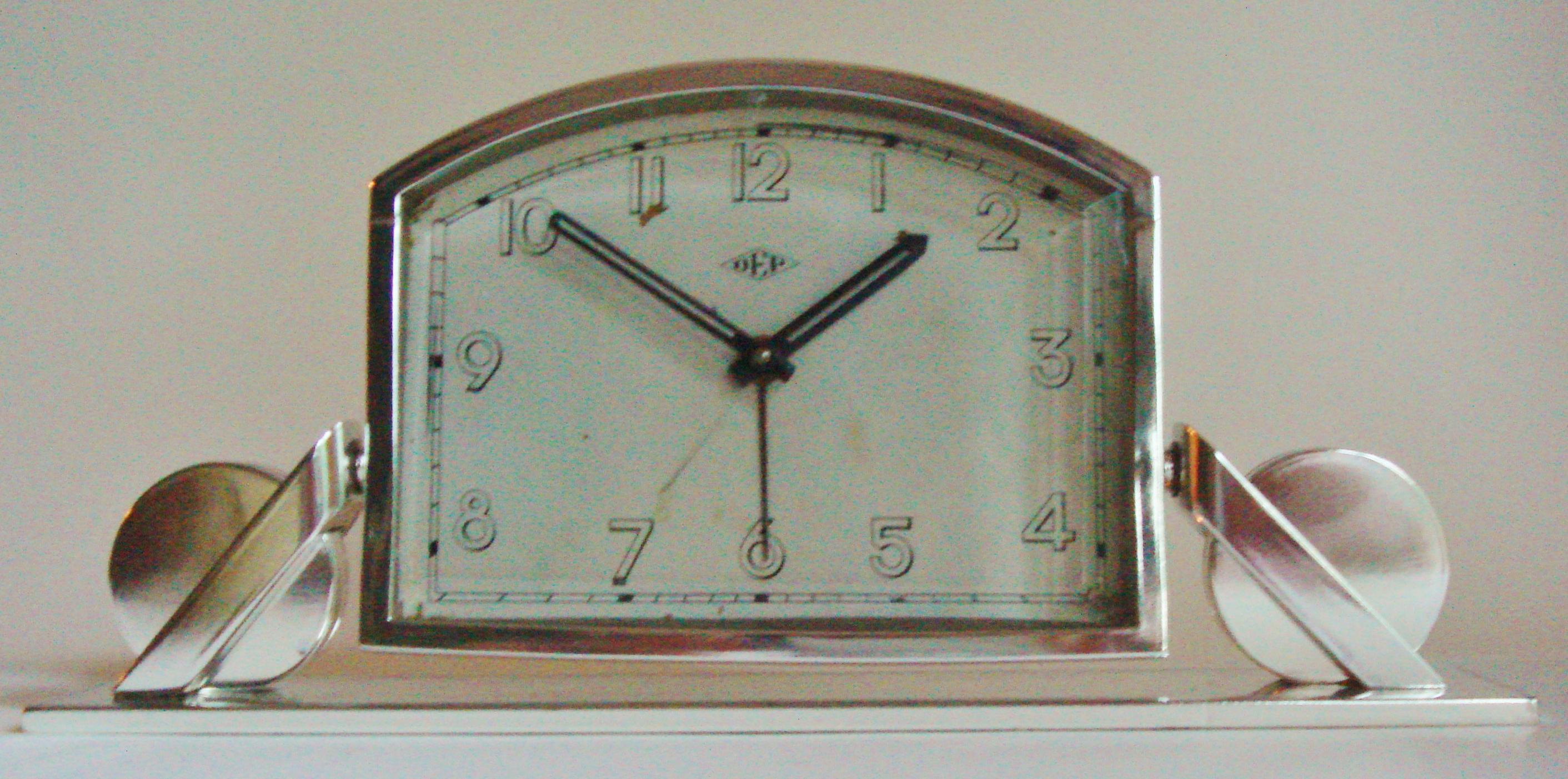 This beautiful French Art Deco chrome alarm/desk clock features a very strongly designed and intricate geometric base. The clock is working well, is in excellent vintage condition and with only a couple of age flaws to the painted face (these can be