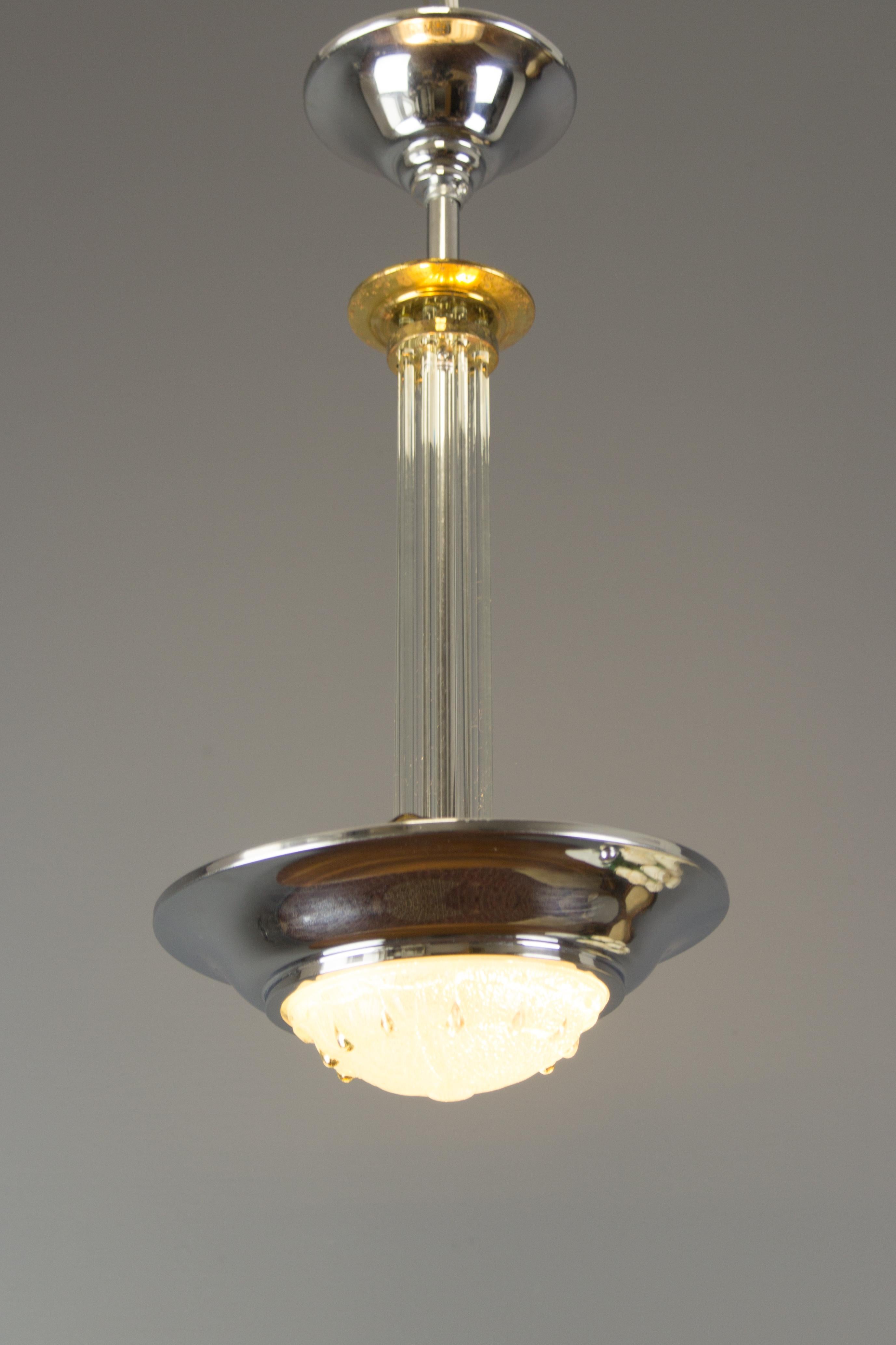 French Art Deco chandelier/pendant light features a chromed brass frame with an Ezan-style relief glass dome and glass rods center. Two sockets for B22 size light bulbs.
Dimensions: Diameter 25 cm / 9.84 in, height 51 cm / 20.07 in.
The light