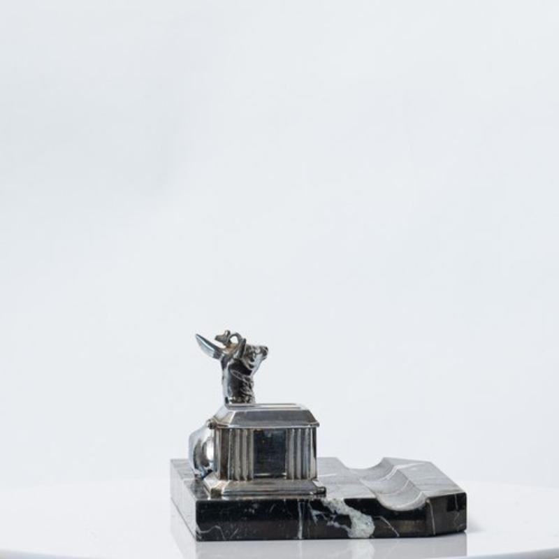 A French Art Deco chromed inkwell with a deer motif on a marble base is a stylish and elegant piece of desk accessory from the 1920s-1930s.

The Art Deco movement was known for its emphasis on geometric shapes and streamlined designs, and this