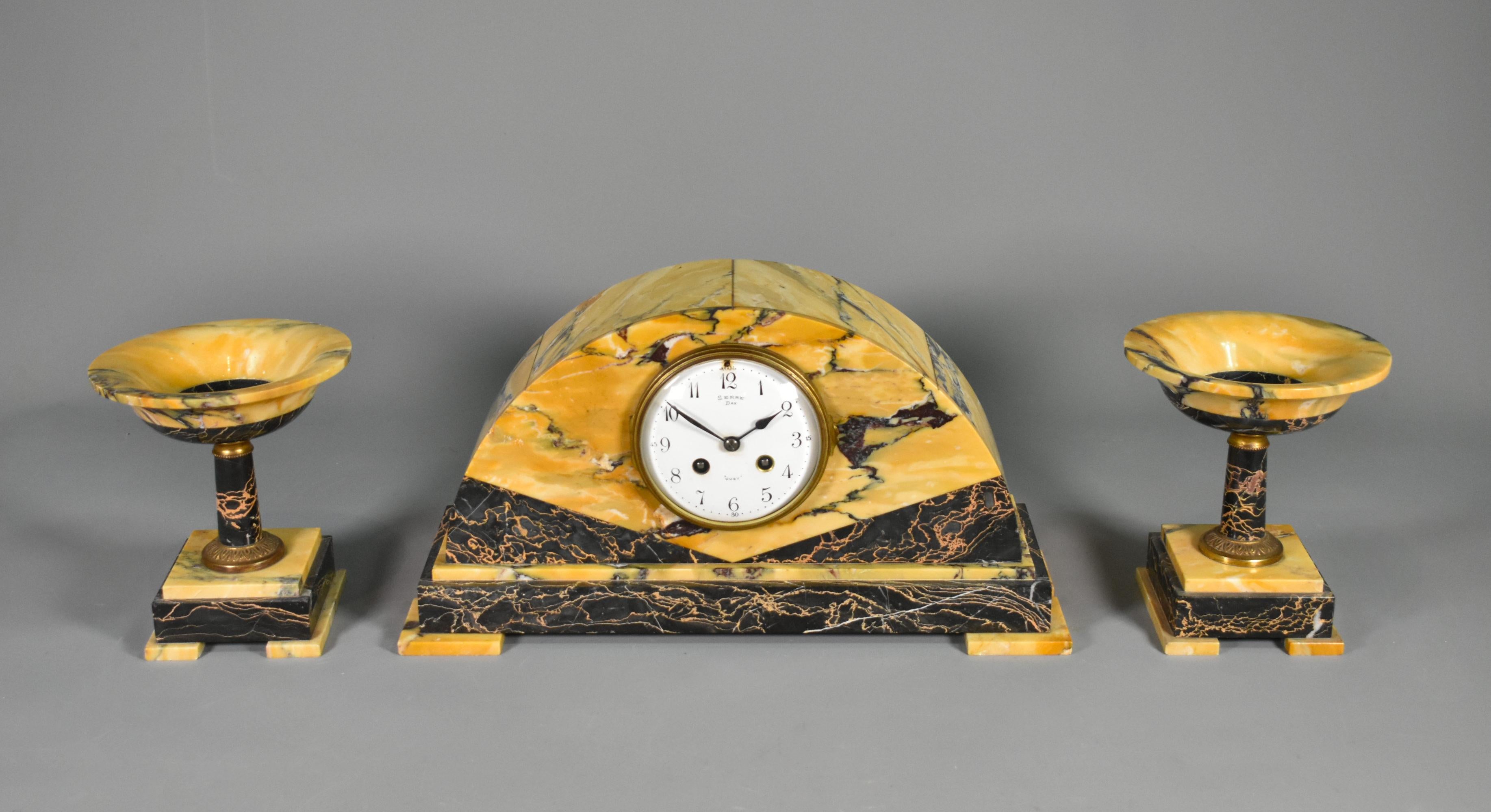Set di orologi e guarniture in stile Art Déco francese
 
Questo attraente orologio francese in stile Art Déco ha una forma demi-lune e una guarnitura coordinata.
 
L'orologio è realizzato in marmo Broccatello di Siena e Portor, a contrasto, che si
