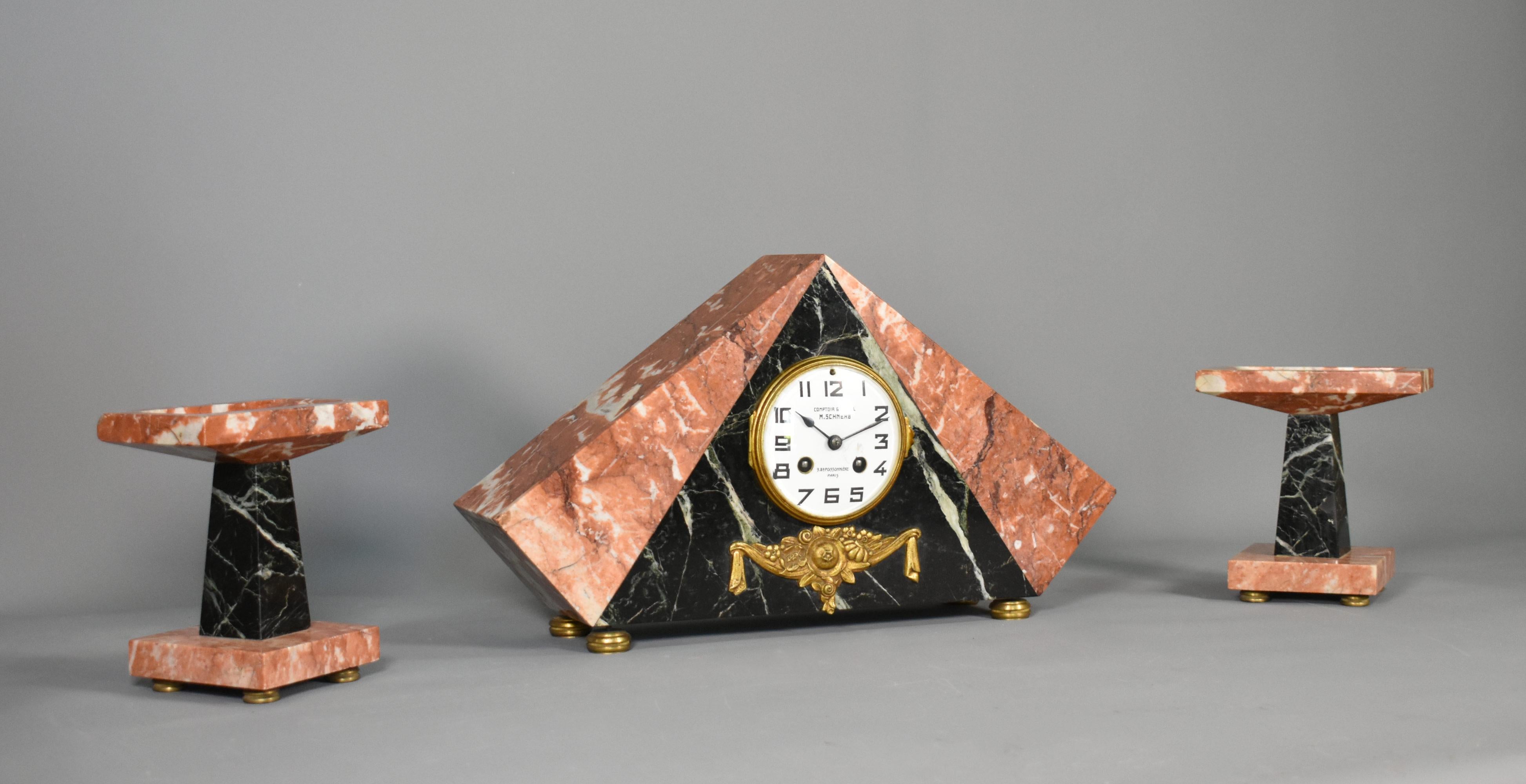 French Art Deco Clock Set by M Schnerb, Paris 

This impressive Art Deco Clock Set is formed in a pentagon shape of contrasting marbles and a decorative floral garland in brass at the base at the front. 

Crafted by M Schnerb, Paris, the movement