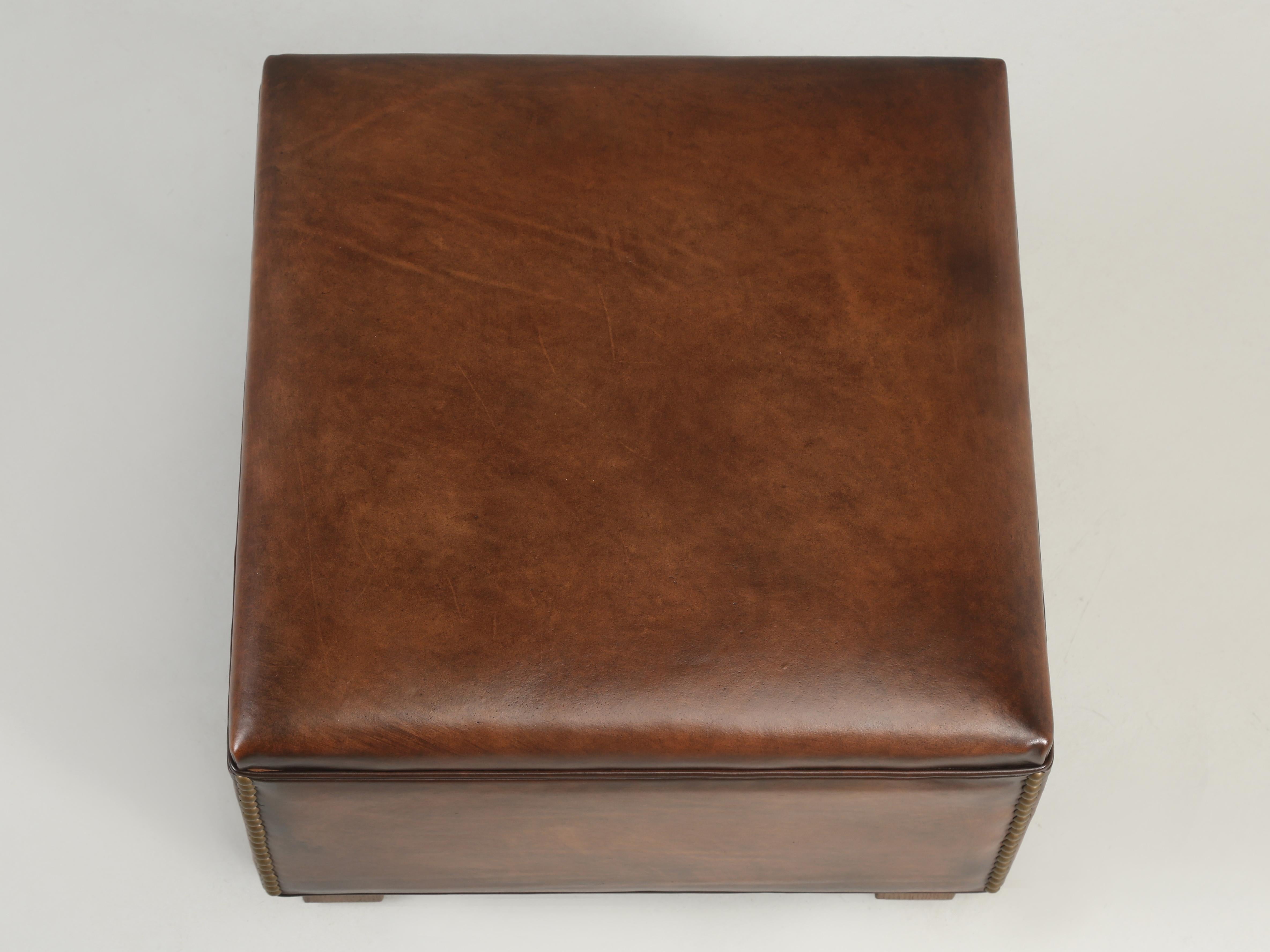 French leather club chair ottoman or foot stool. In our quest for purchasing French leather club chairs, we would occasionally come across their matching leather ottomans. Some will have a flat top like this ottoman and others more of a padded top