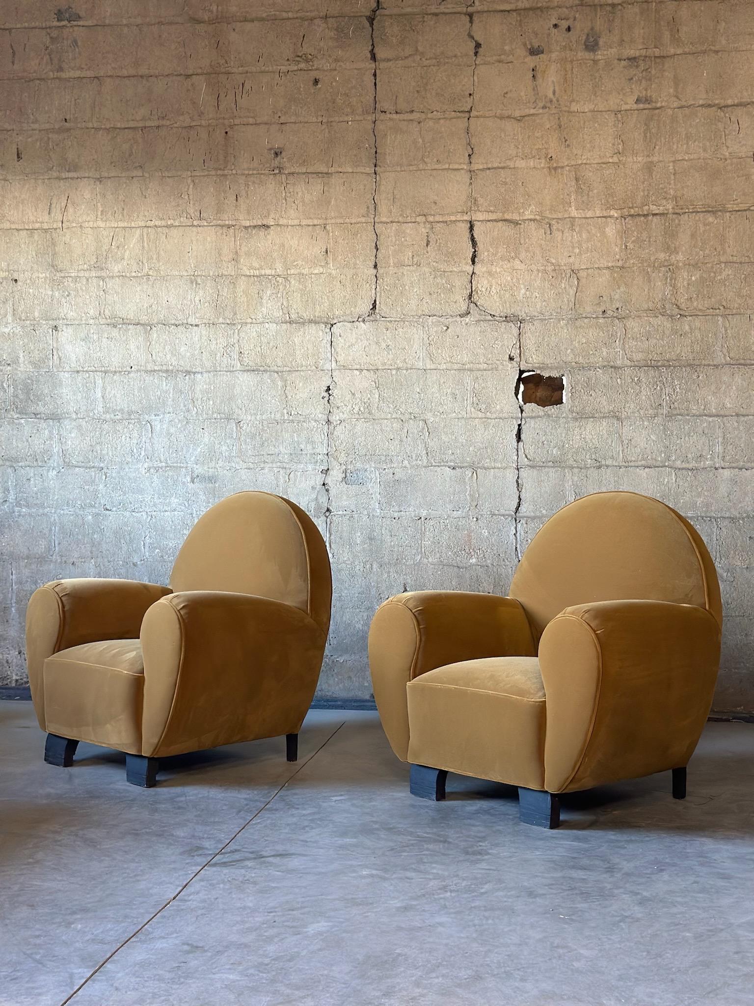 An amazing Art Deco pair of club chairs from France. Recently refurbished and recovered in a beautiful mustard mohair. A unique shape and large scale design make this pair extra special!