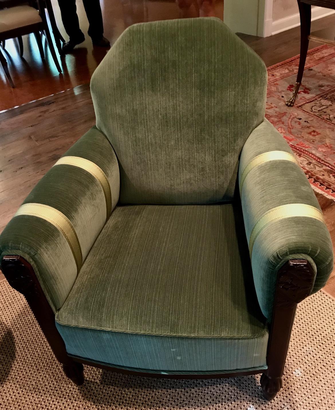 Art Deco period armchairs from France c. 1935 featuring a dark walnut frame. Freshly upholstered in Kravet green cotton velvet fabric and detailed with Samuel & Sons silk trim in double rows on the arms. The relief carving in the wood on the