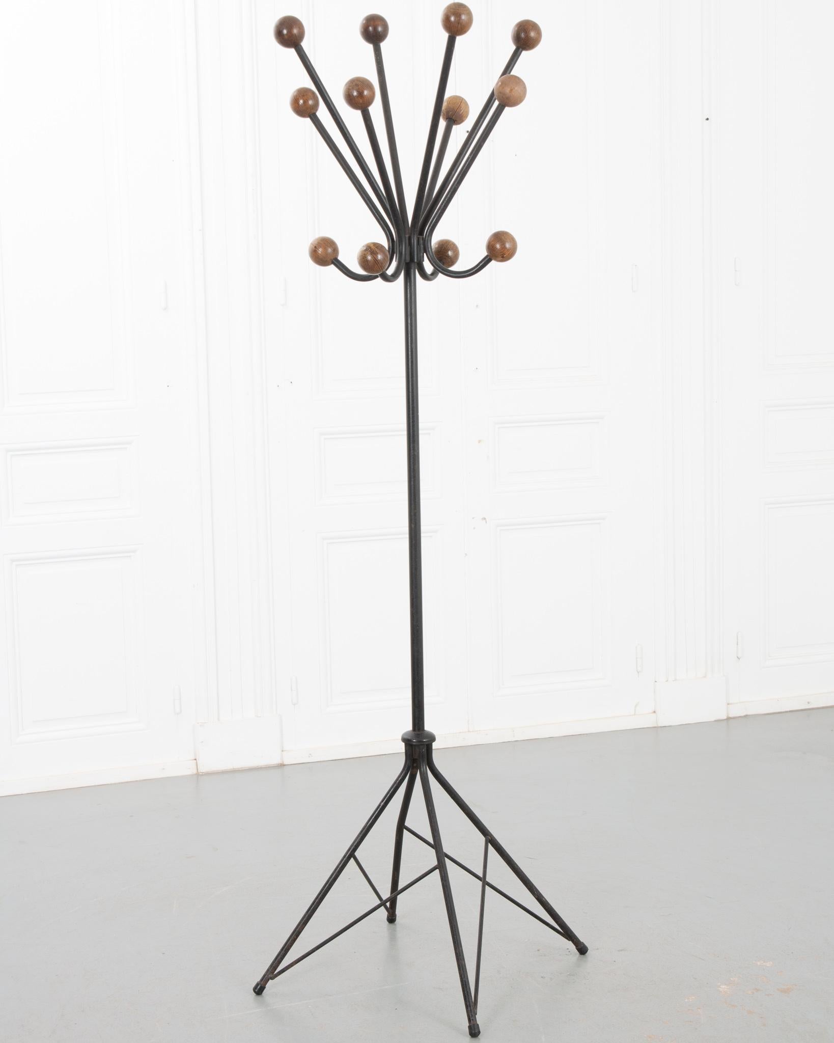 A unique Art Deco style coat stand from France. The sleek black metal frame is fixed with twelve wooden spheres for hanging hats and coats on. Elevate any space by placing this stand near the entryway. Make sure to view the detailed images for a