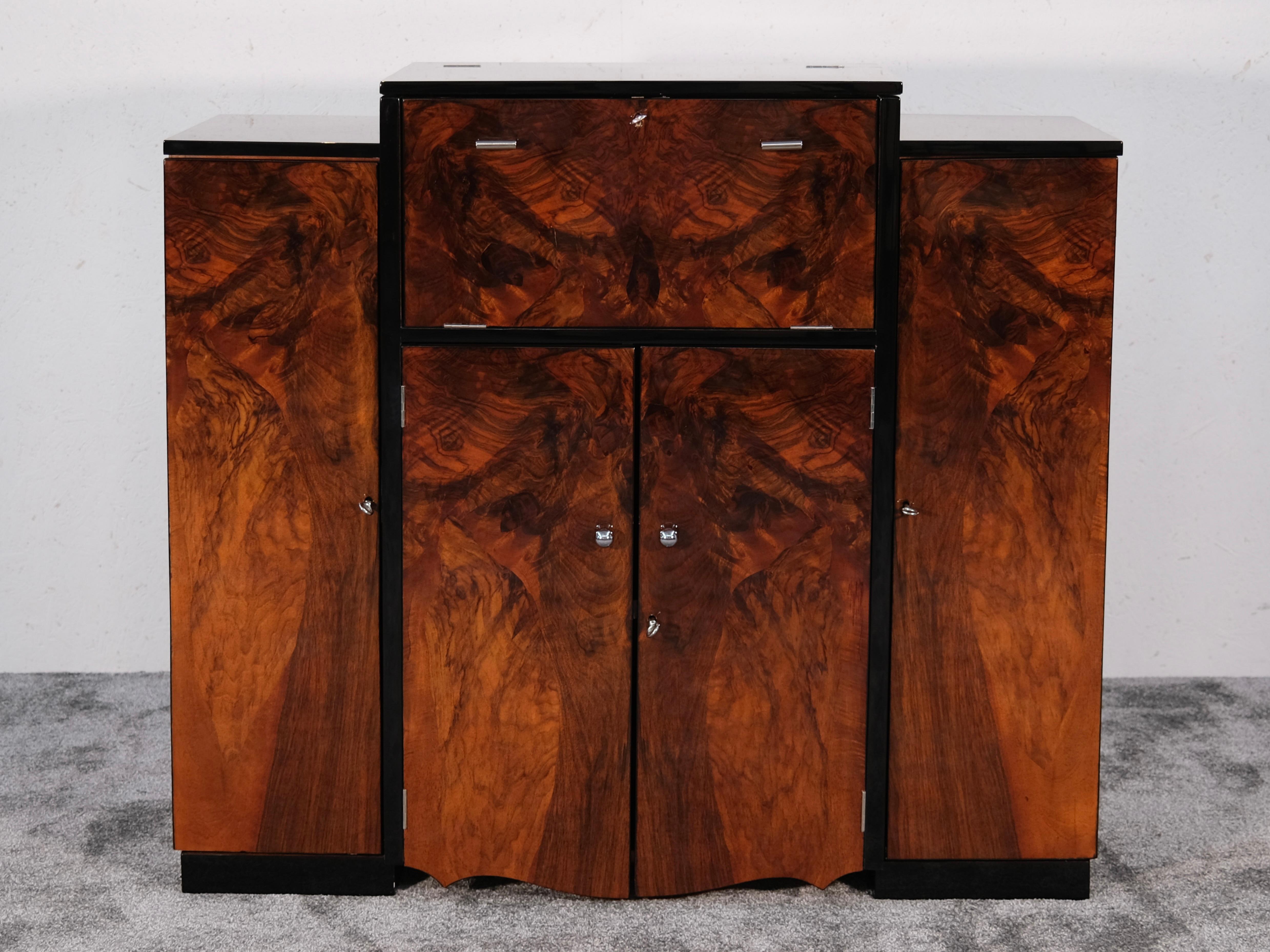 This rare and beautifully restored Art Deco bar cabinet from the 1930s is the perfect fusion of form and function, offering a stunning solution for those seeking a vintage liquor cabinet, a cocktail sideboard, or an elegant drinks cabinet that