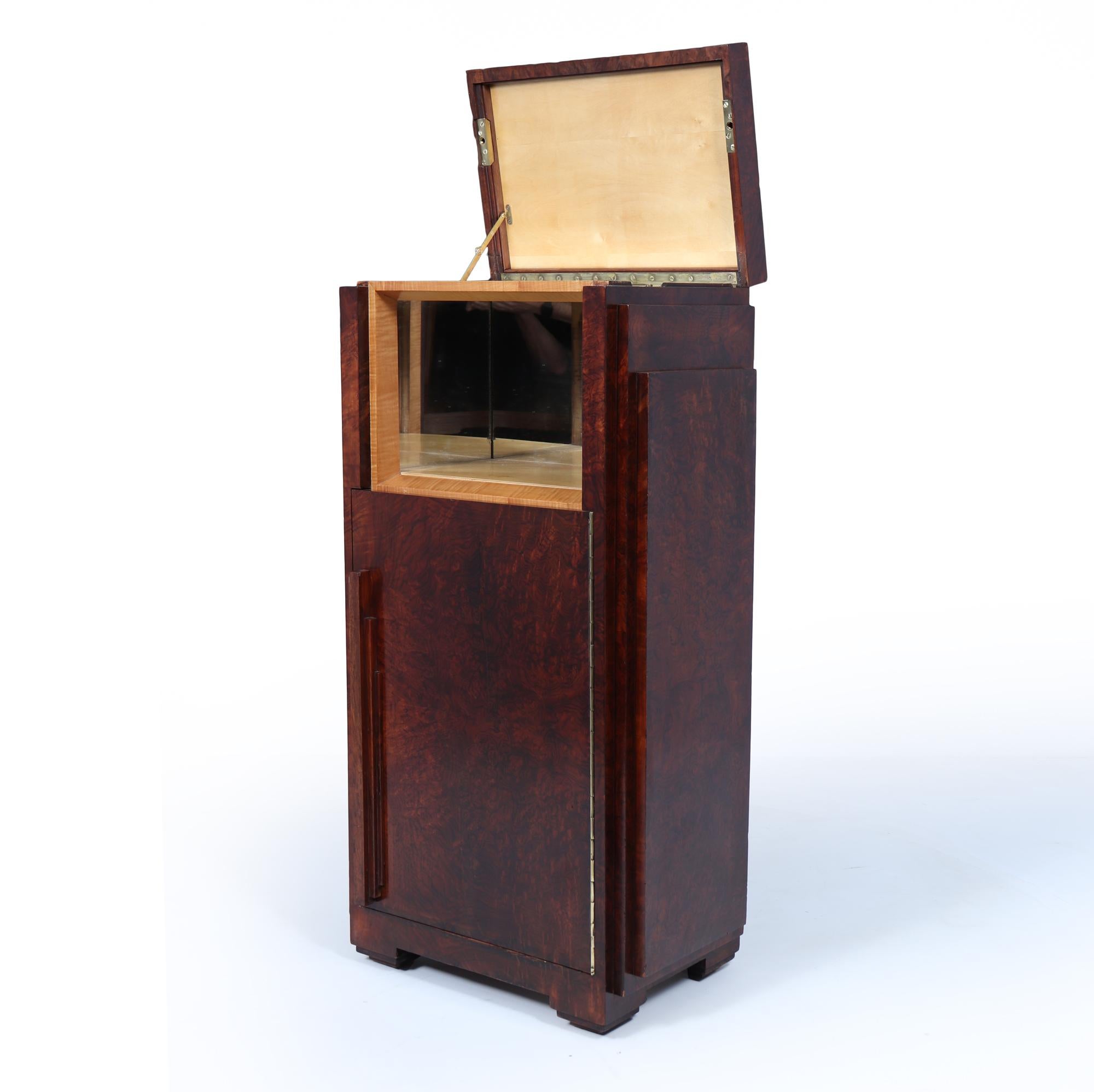 French Art Deco Cocktail Cabinet
This French Art Deco cocktail cabinet features a distinctive lift-up lid and an innovative door opening mechanism, showcasing the era's signature style and craftsmanship. The design is defined by sleek lines and