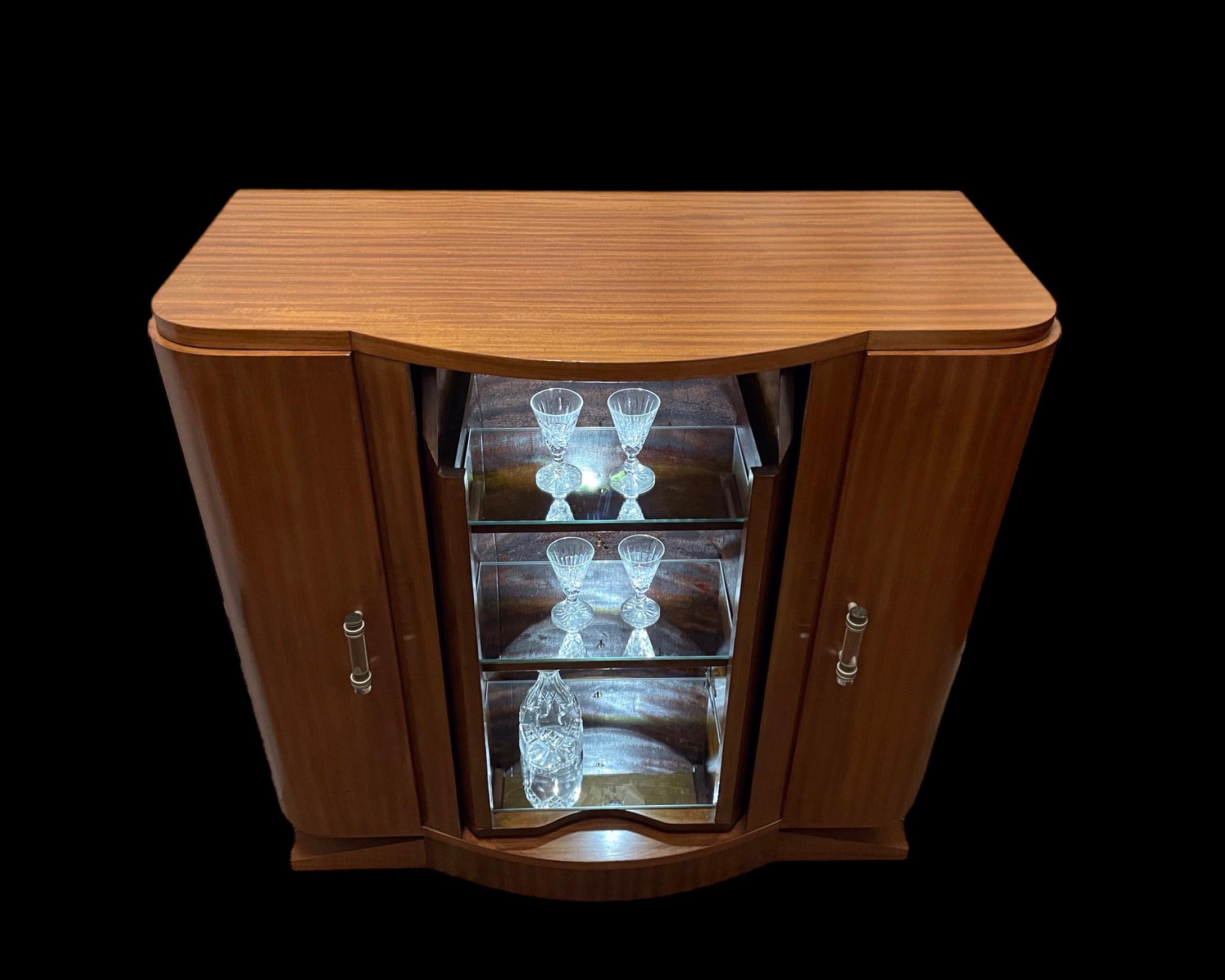 A French Art Deco Cocktail Cabinet, with two cupboards to each side opening to reveal two shelves in each. The central section with four faux drawers, that pivot to reveal three mirrored shelves, each with a battery operated LED spot light. Superb