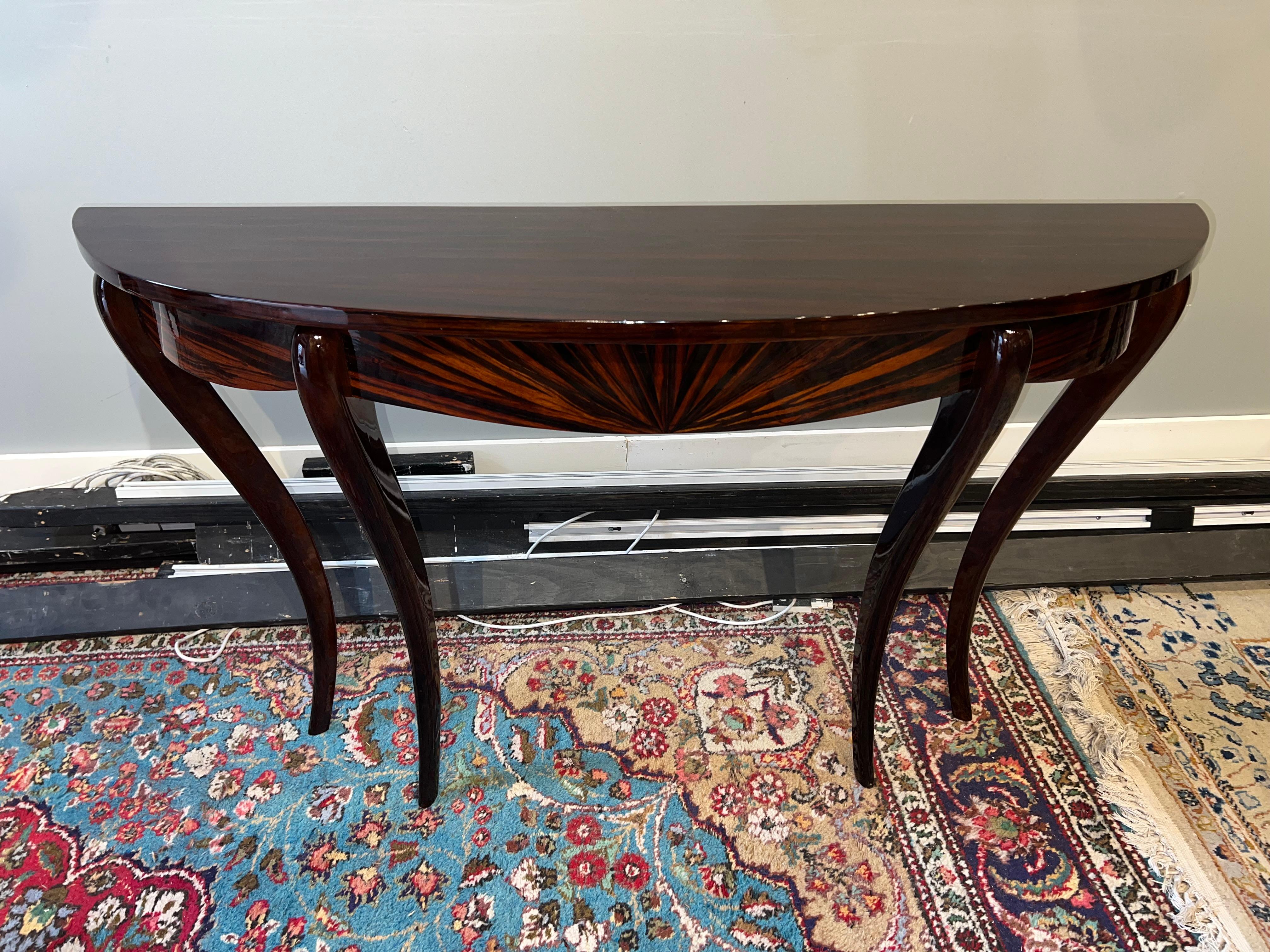 Elegant Art Deco French Consoles made out of Macassar wood. Console top displays beautiful wood grain. Supported by 4 thin curved legs. 
For better stability console need to be attached to the wall.
 Condition is perfect. restored. 
France, c.