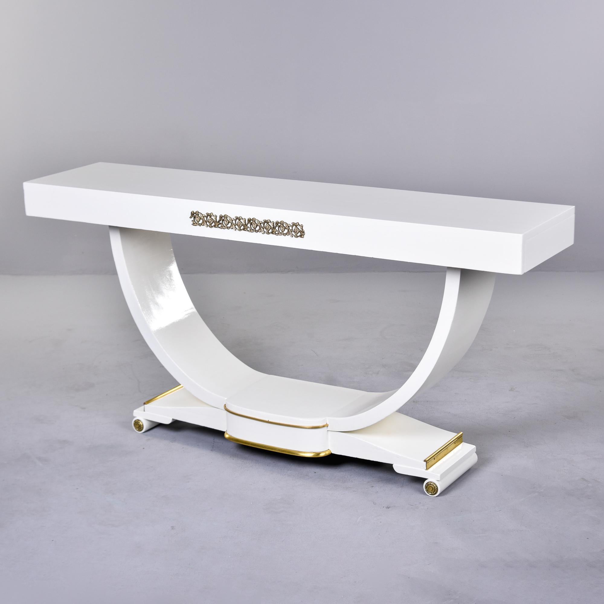 Found in France, this console has a curved support and stepped platform base. New, professionally applied white finish with brass trim. Unknown maker. Two tables in this finish and style available at the time of this posting. Sold and priced