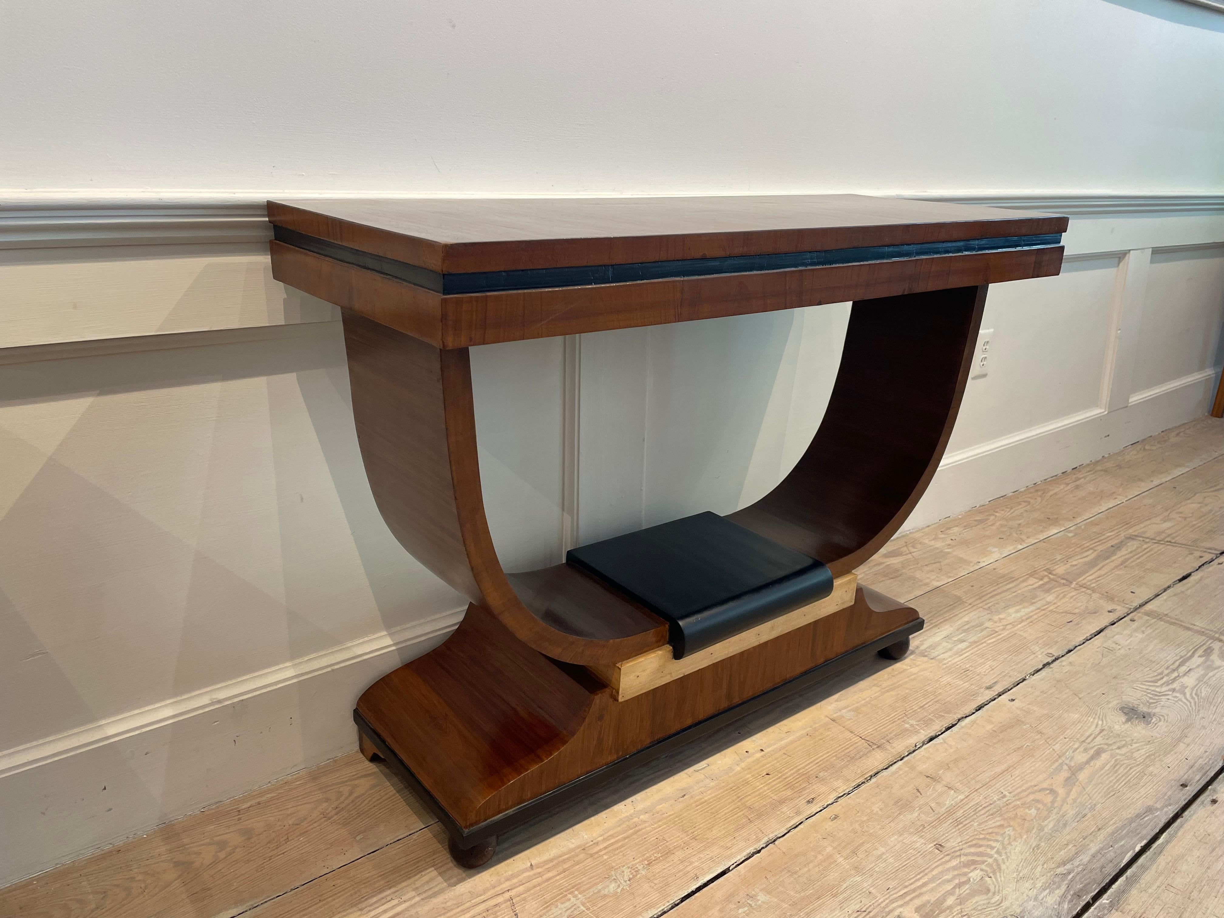 Une belle table console Art Déco française avec une base en forme de lyre et de U.  Le bois dominant est le teck massif, avec des bordures ébénisées autour du tablier et de la base, et une combinaison de teck ébénisé et d'épicéa clair au sommet de