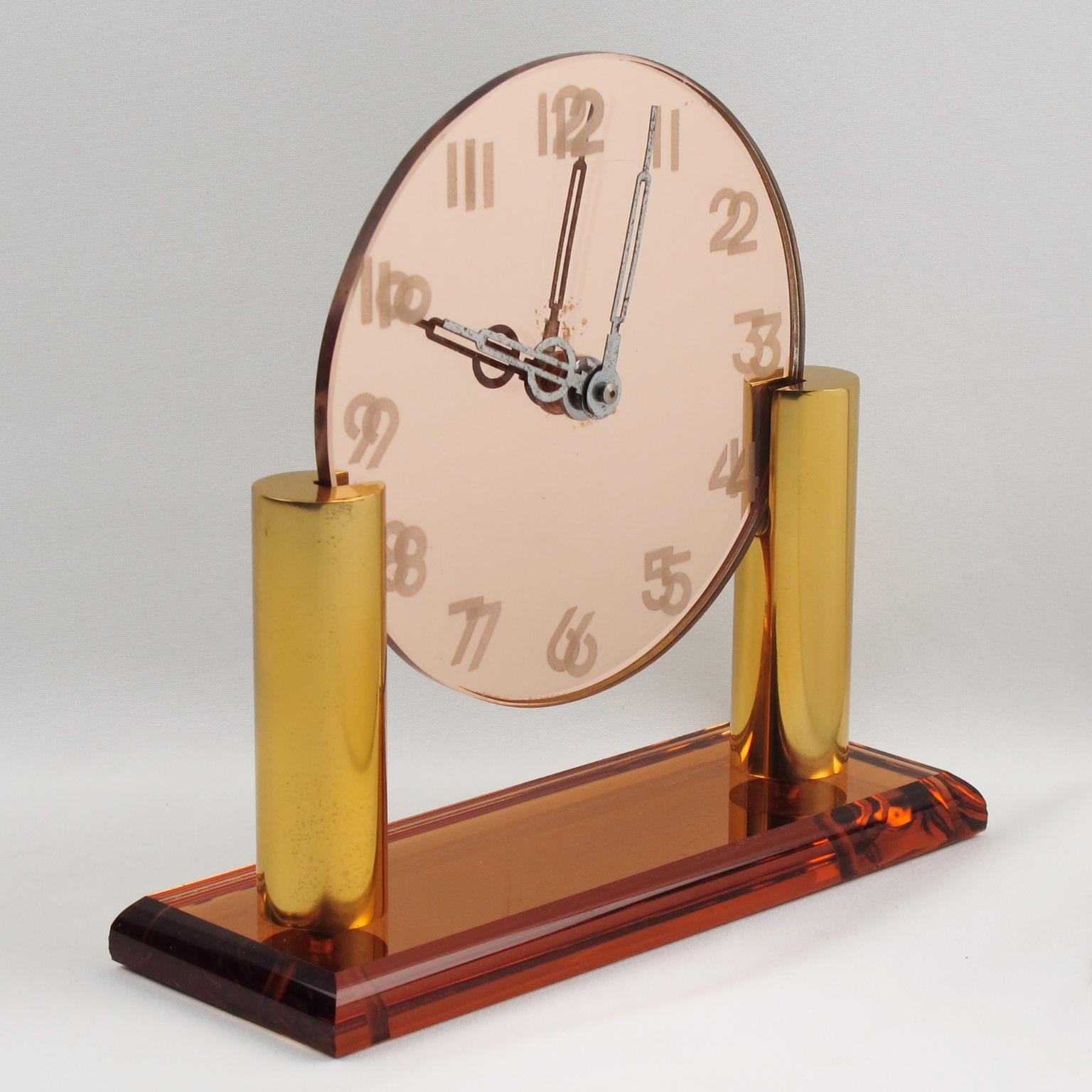 Lovely French Art Deco desk, vanity, table clock. Original Art Deco mirrored copper and peach glass clock with heavy gilded brass holders. Base of clock is made of a thick mirrored glass plinth in copper glass color with two round geometric gilded