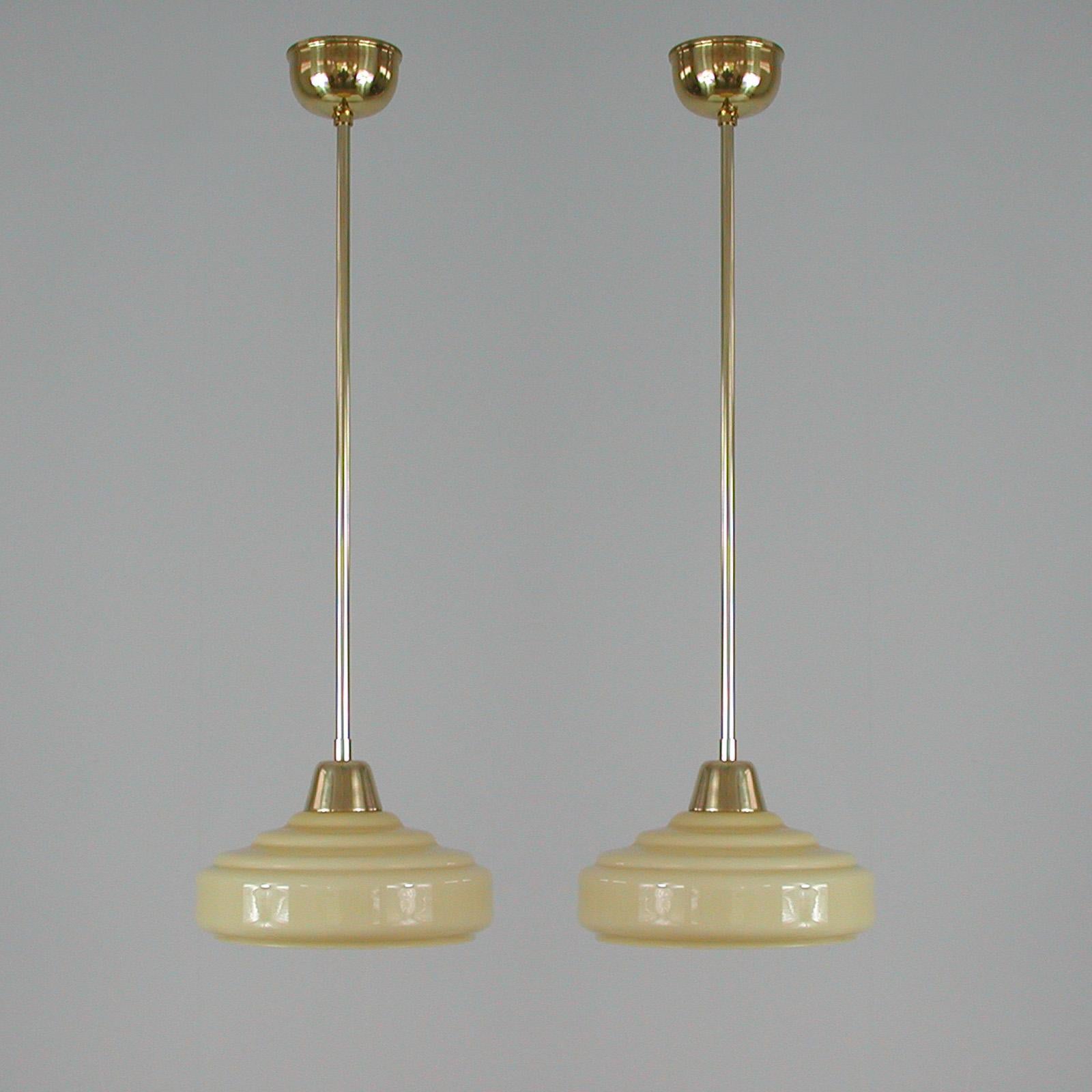 These elegant pendants were designed and made in France in the 1930s-1940s. The lamps are made of brass and have got cream colored glass shade. Good vintage condition with one E14 socket.

The lamps have been rewired and re-electrified for use in