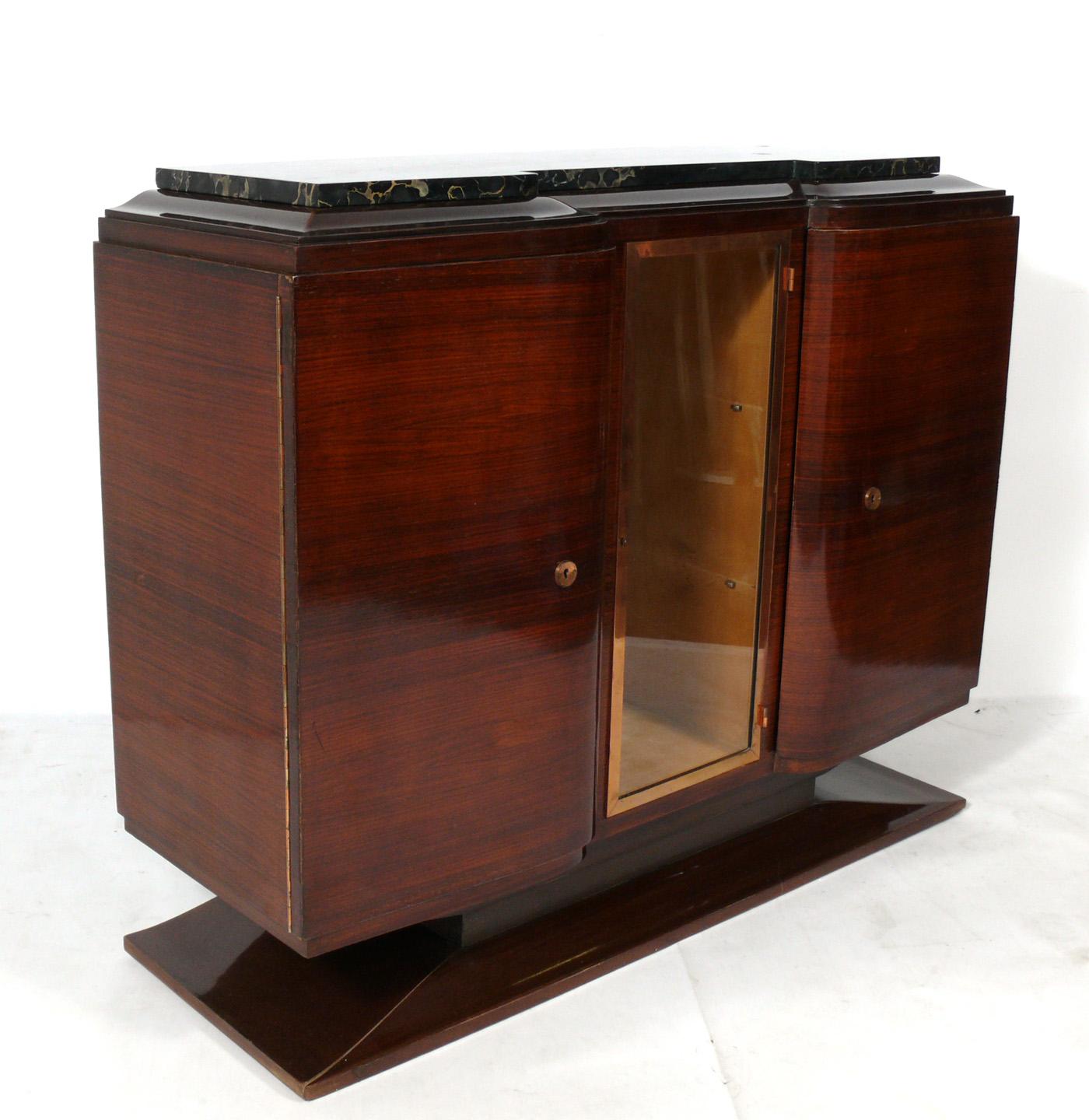 French Art Deco rosewood and marble-top credenza, France, circa 1930s. It is a versatile size and can be used as a credenza, bar, server, buffet, chest, or media cabinet. It offers a voluminous amount of storage, with the right and left doors