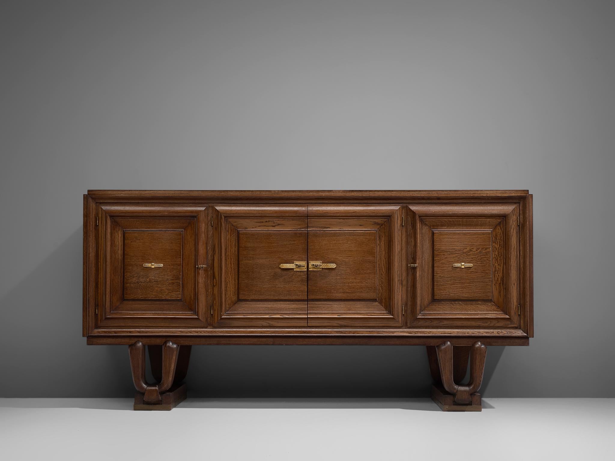 Credenza, in oak and metal, France, 1930s.

French Art Deco cabinet in cerused oak with high, sculpted legs. Designers Charles Dudouyt, Jean-Charles Moreux and Gaston Poisson are masters in this style. The front features three dimensional carvings