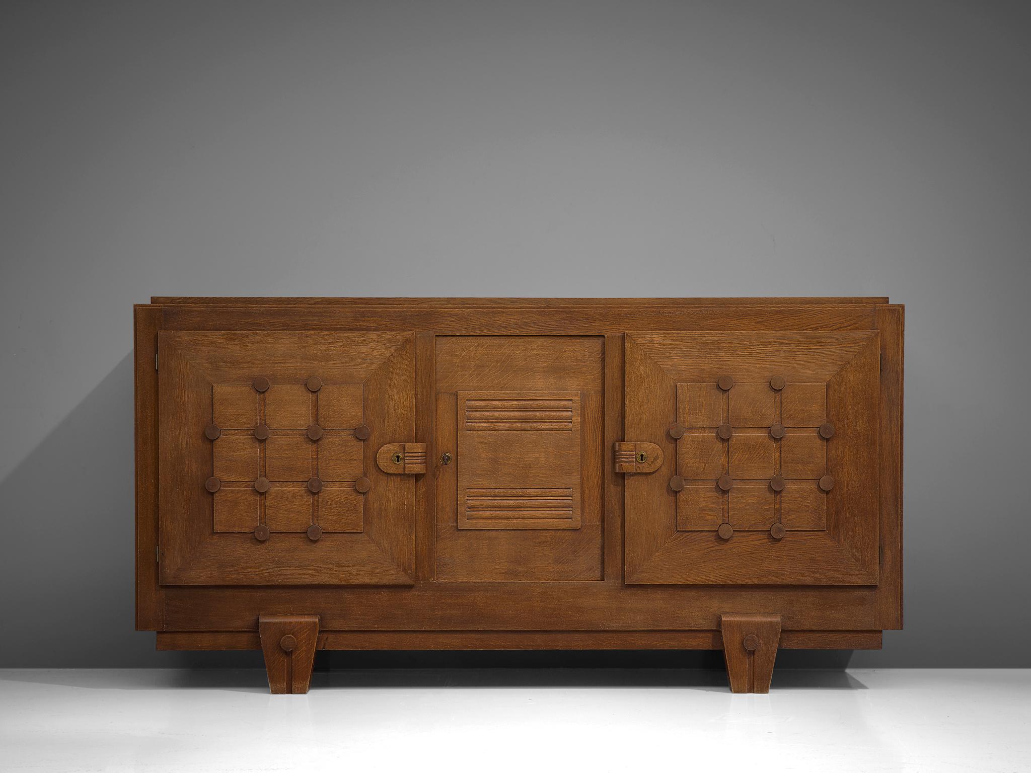 Credenza, oak, France, 1930s.

Sturdy credenza with stunning graphical details in the door panels. Featuring a grid with wooden dots on the intersections, which give this cabinet a vibrant appearance and emphasize its dimensionality. This two-door