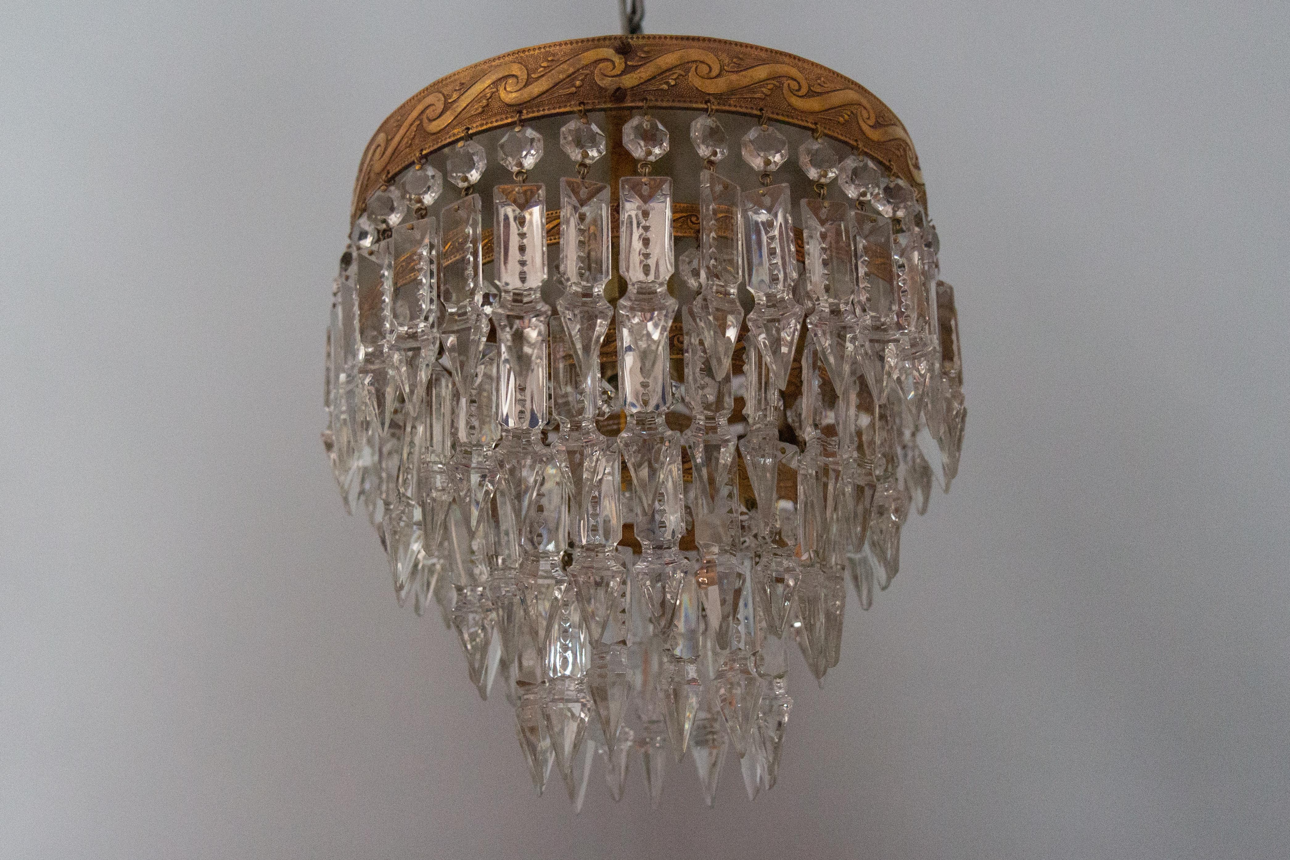 French Art Deco crystal glass and brass ceiling light or flush mount, the 1930s.
This adorable Art Deo ceiling light or flush mount features a four-tier brass frame with impressive crystal glass prisms and beads. 
One new socket for E27 (E26) size