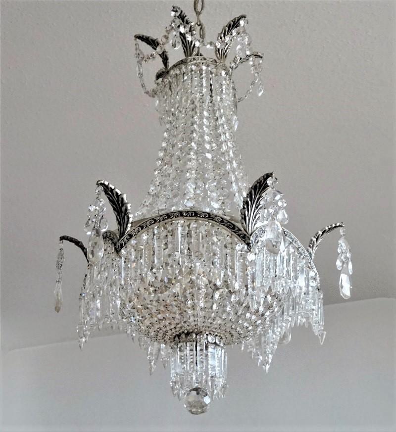 A fine Art Deco faceted crystal sac-de-pearl chandelier with silvered bronze frame surrounded by long cut crystal hangings, all crystals hand knotted, France, circa 1920-1930. This wonderful chandelier is in very good condition, professionally
