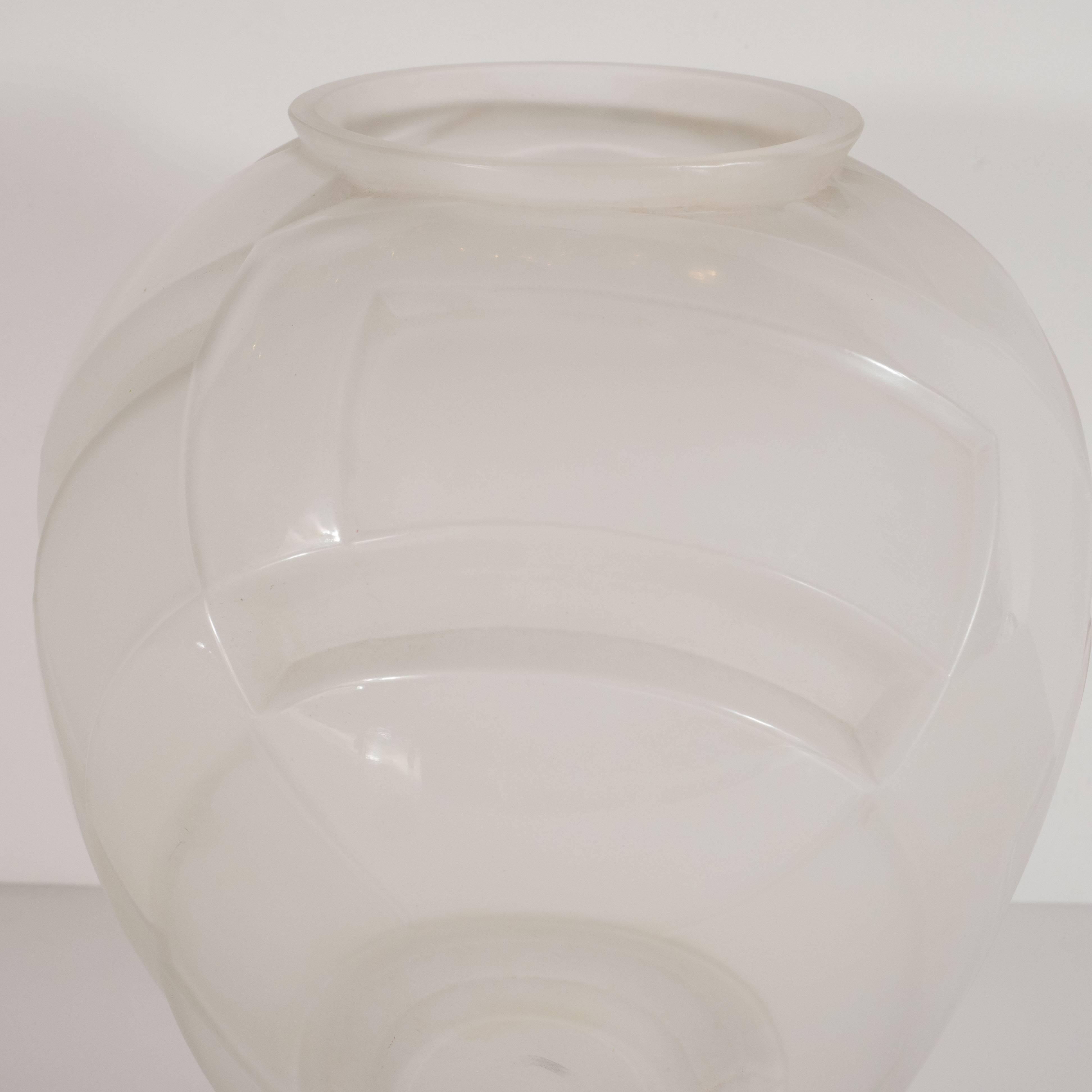 This refined glass vase was handblown by Andre Hunebelle, one of the finest glass blowing studios of the period- in France, circa 1930. It offers curvilinear cubist geometric patterns etched in the glass throughout, and a gently expanding body that