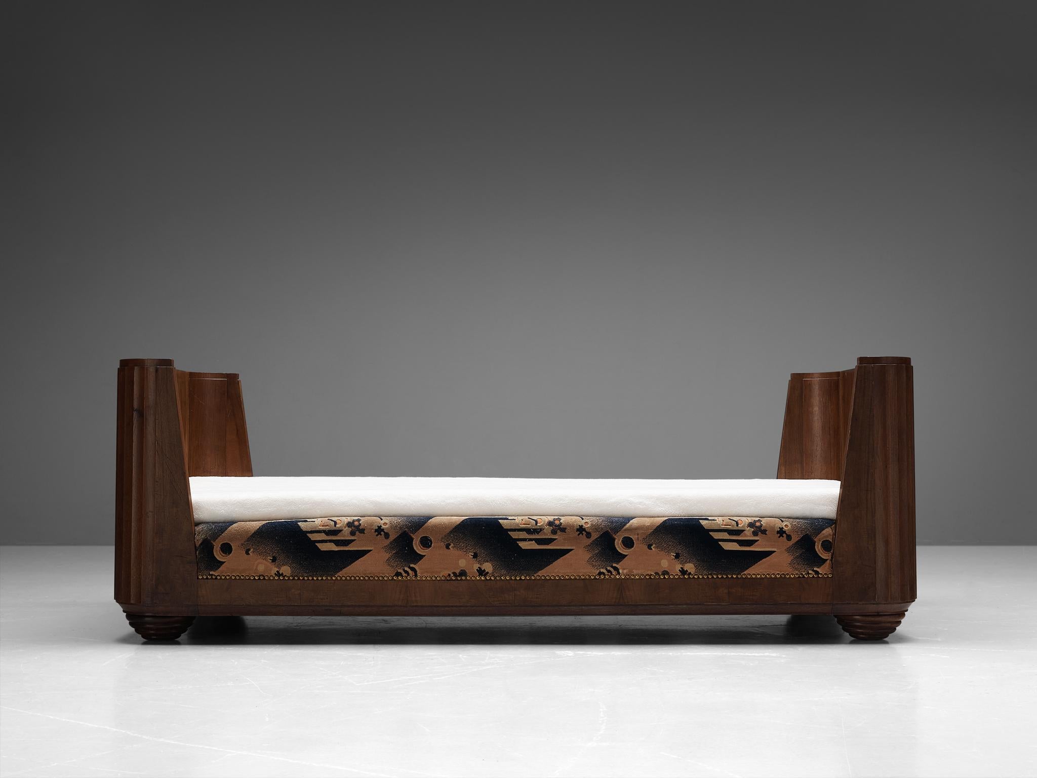 Art Deco daybed, walnut, fabric, France, 1930s. 

Alluring Art Deco daybed with a walnut frame. Both sides contain an even sized headboard of which the outer edges are rounded inwards, creating a wonderful graceful exterior. The outer lines of its