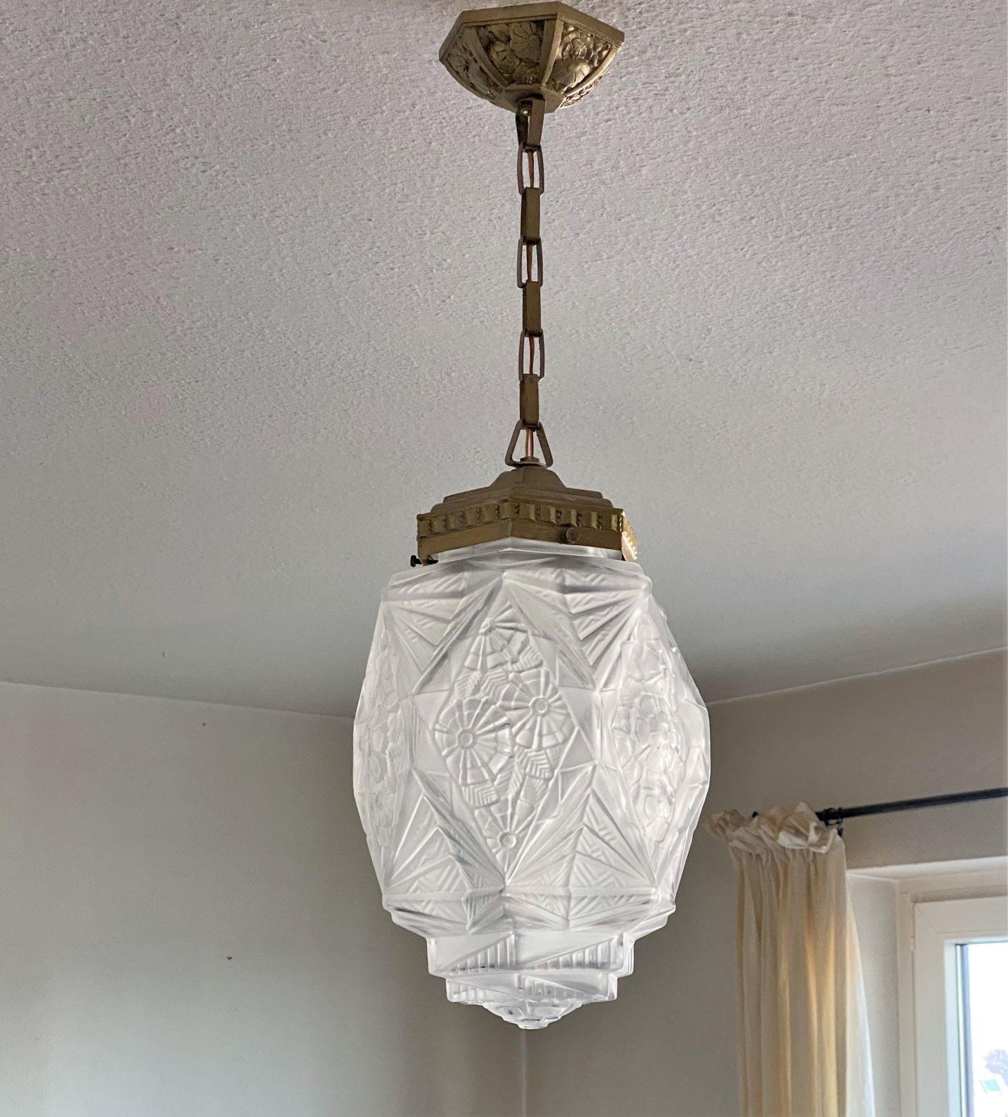Art Deco pendant in Deguè style, France during early 1930s. Trick, clear frosted glass shade with geometric themed reliefs, original nickel plating mounts with beautiful ceiling canopy. It takes one large sized Edison E27 bulb up to 100 watts. In