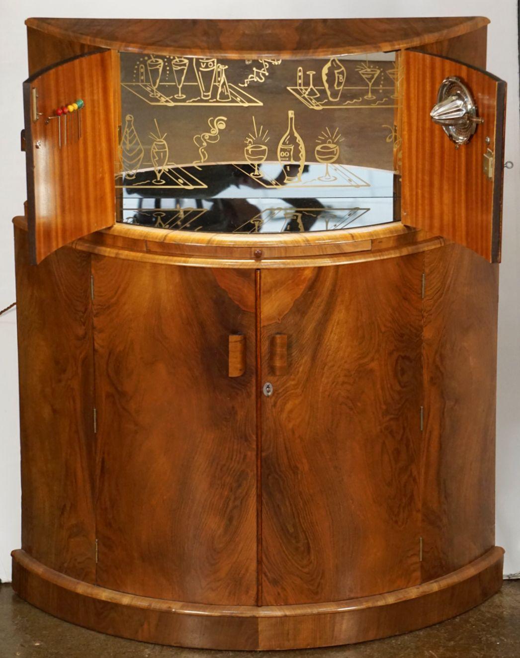 A fine French upright demi-lune cocktail bar cabinet or drinks cupboard of burled walnut from the Art Deco Period.

Featuring a dry bar top with pull-out slide for preparing cocktails - with two doors opening to reveal a lighted, mirrored glass