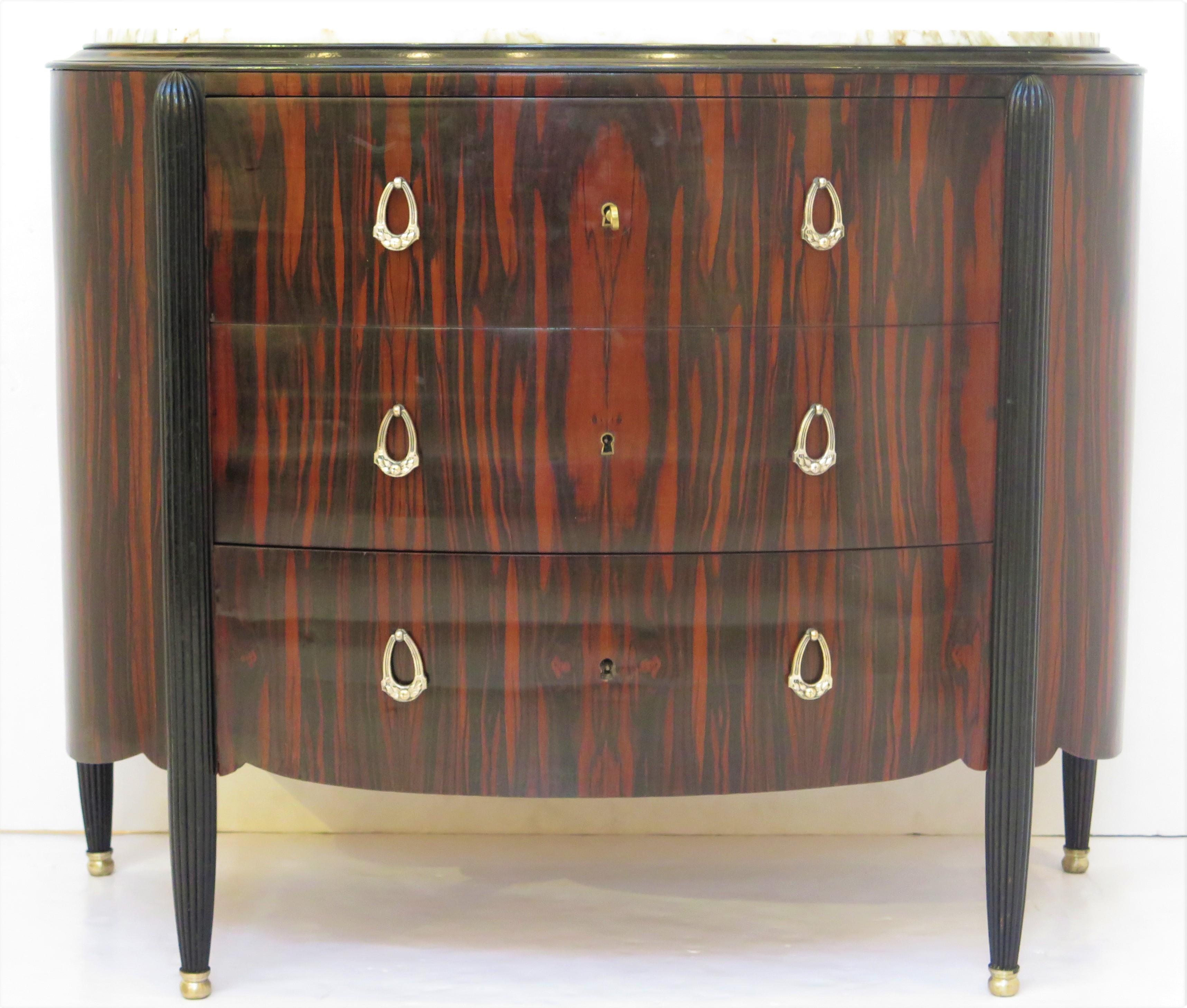 French art deco demilune commode, possibly macassar ebony, inset marble top, over tree drawers, rising on melon ribbed legs. 20th Century.