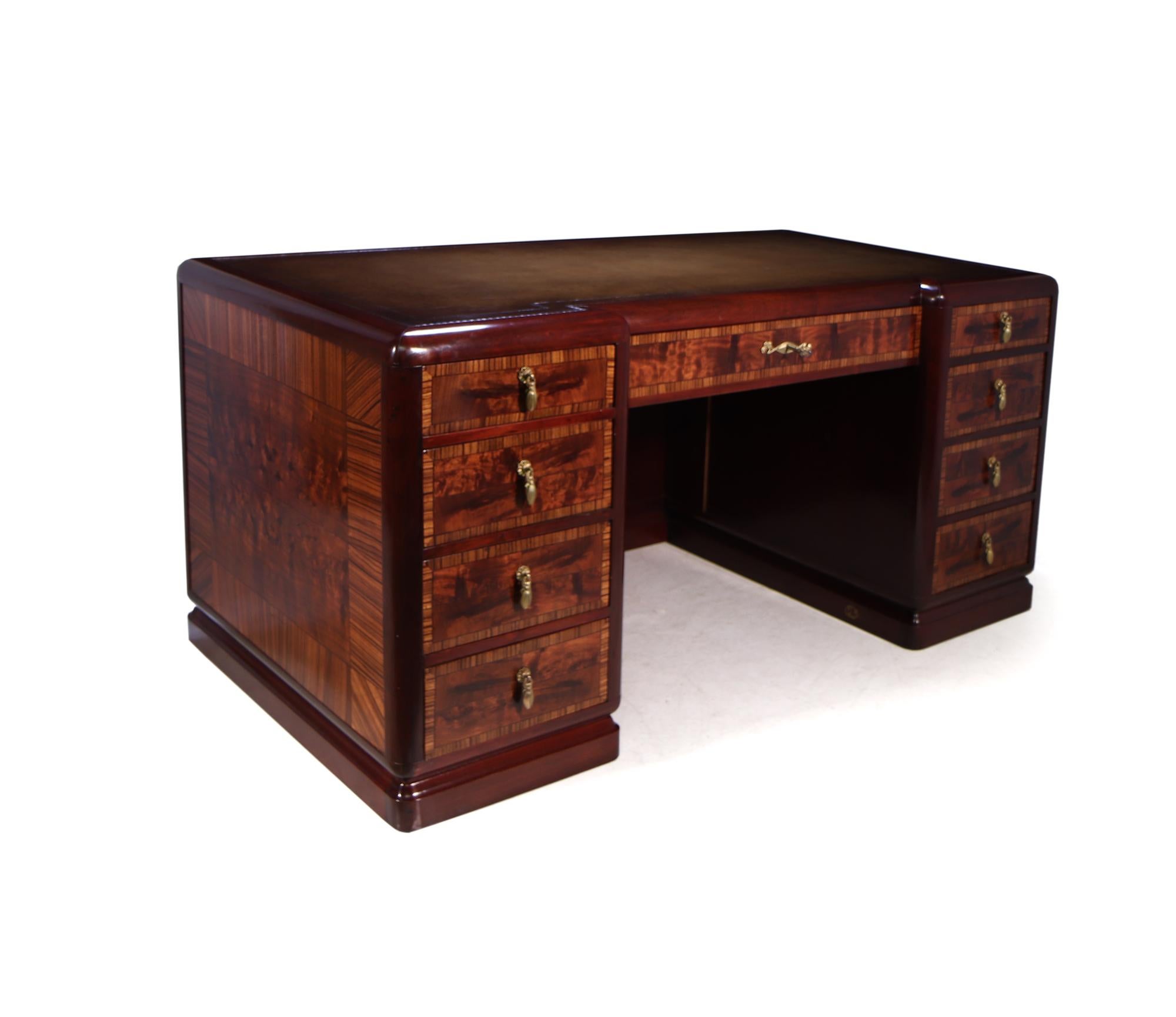 A French Art Deco desk produced by Louis Majorelle of exceptional quality as you would expect from this French Cabinetmaker. The use of unusual exotic veneers book matched and spaced with ebony string line, to the front it has nine lockable drawers