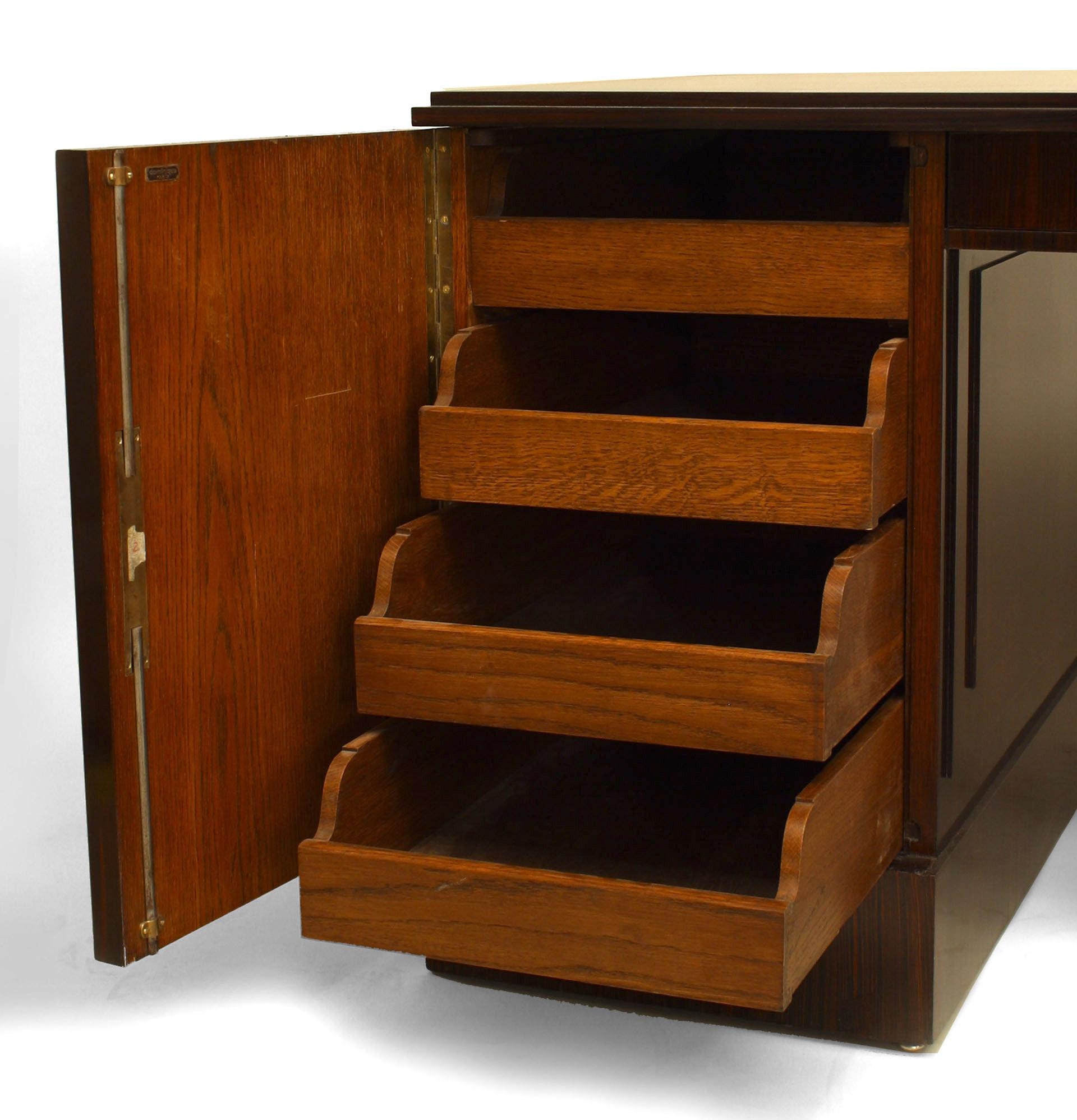 Bureau Art Déco en bois de calamandre à deux pieds, les portes ouvrant sur des tiroirs et des étagères avec garnitures (signé : DOMINIQUE).
 