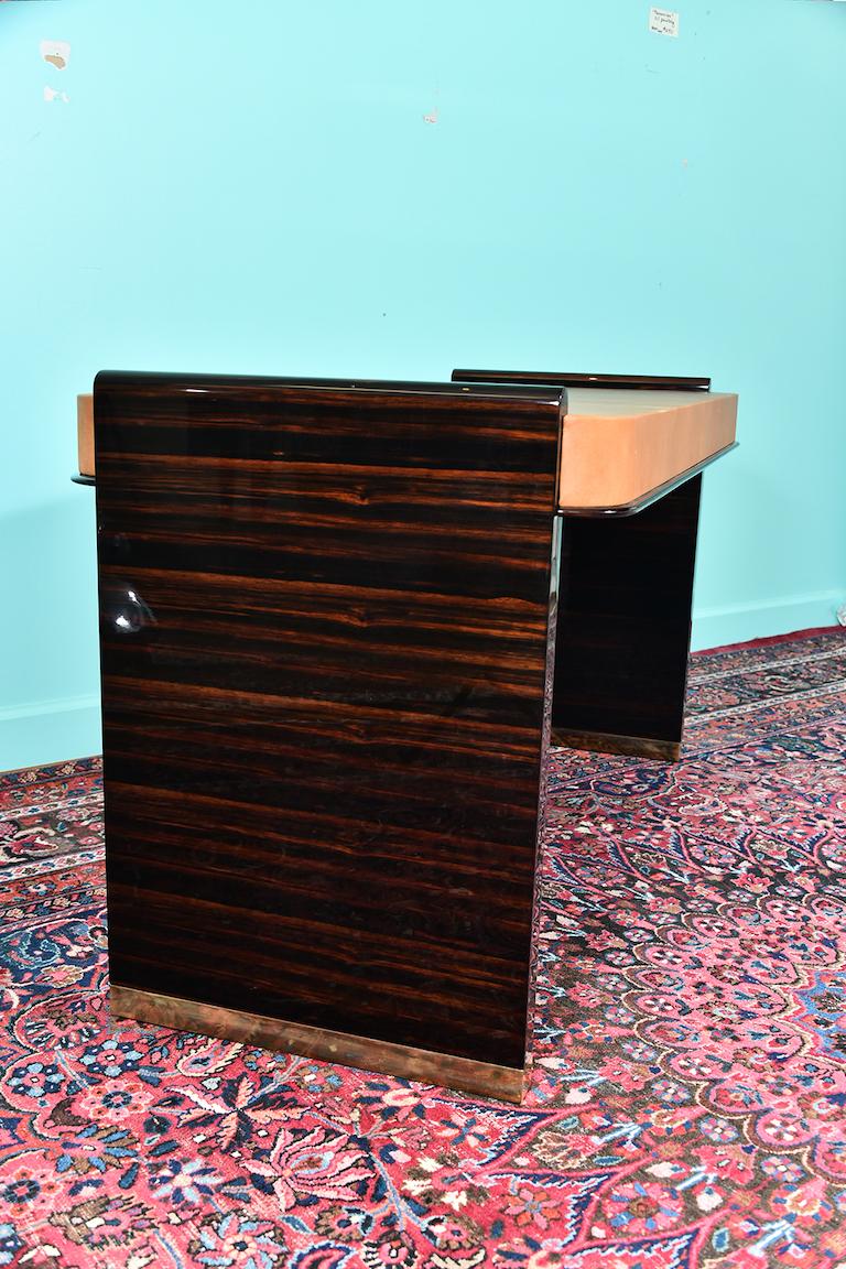 French Art Deco desk and chair in Macassar wood

Desk is made out of the fine Macassar wood, top is covered with cowhide. There are 3 drawers with brass handles and decorative elements on the bottom of each wide wooden leg.
France, circa
