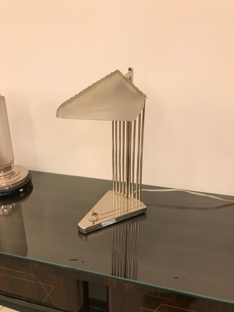 French Art Deco desk or table lamp signed by Genet et Michon. Having geometric shade in frosted glass with polished details. Held by a silvered bronze geometric base. Has been rewired for American use having one candelabra socket. With a max watt of