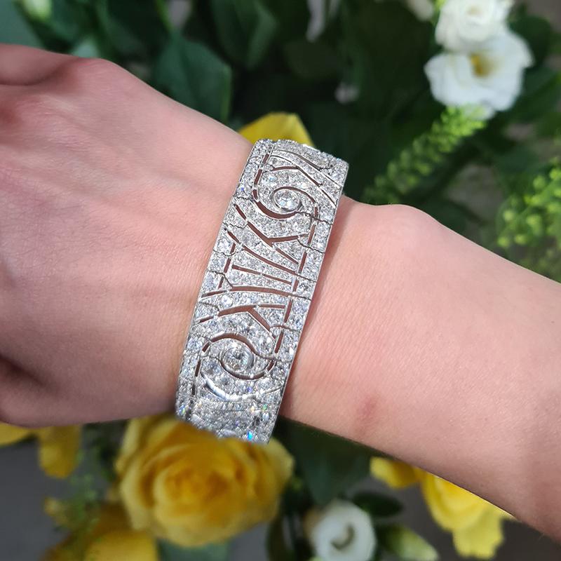 A magnificent French Art Deco diamond and platinum bracelet, set with approximately 20.00 carats of old-cut diamonds, in grain settings, with the larger diamonds in rub over settings, in a design influenced by Ionic capitals, decorated with