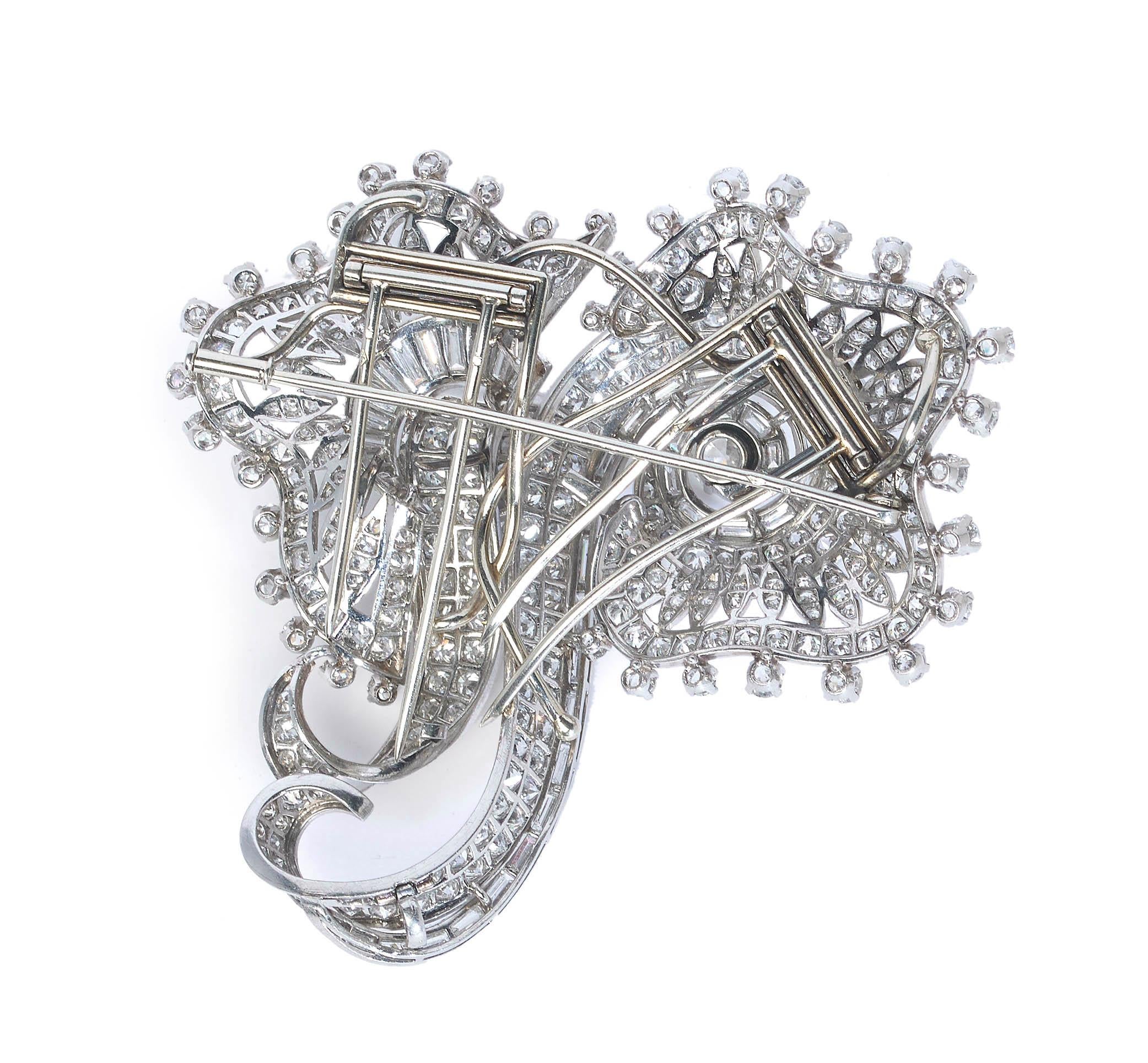 A French Art Deco diamond and platinum double clip brooch, set with round brilliant-cut, Edwardian-cut, eight-cut and baguette-cut diamonds, in an abstract design, mounted in platinum, with French dog head marks. The clip fittings are made of white