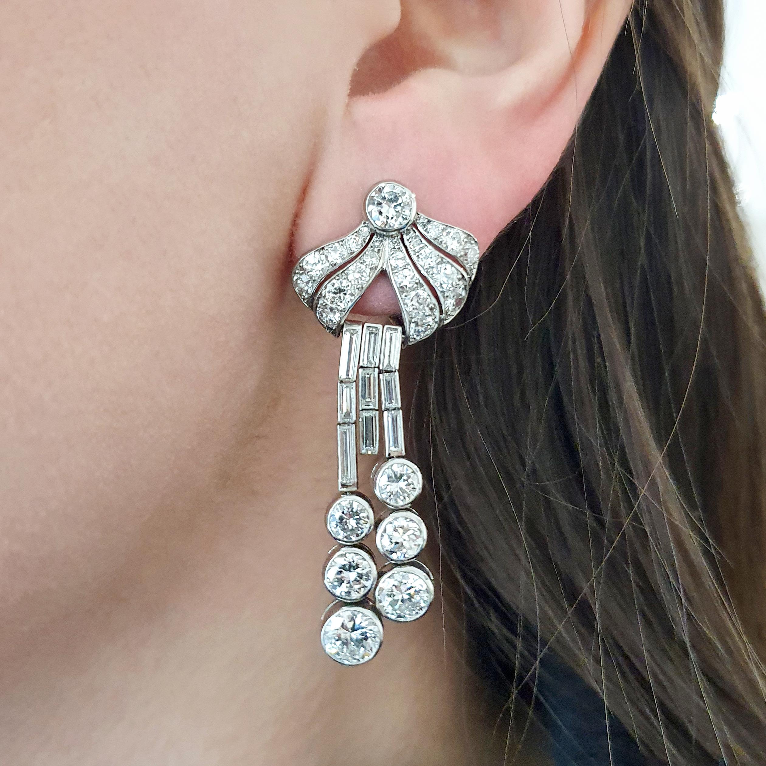 A pair of Diamond and Platinum Earrings.
Old mine cut and Baguette cut Diamond.
French marks.
Circa 1940.
Total Length: approximately 2.00 inches (5.00 centimeters).
Total weight: 22.87 grams.
Those amazing Ear Pendants are a dazzling revival of
