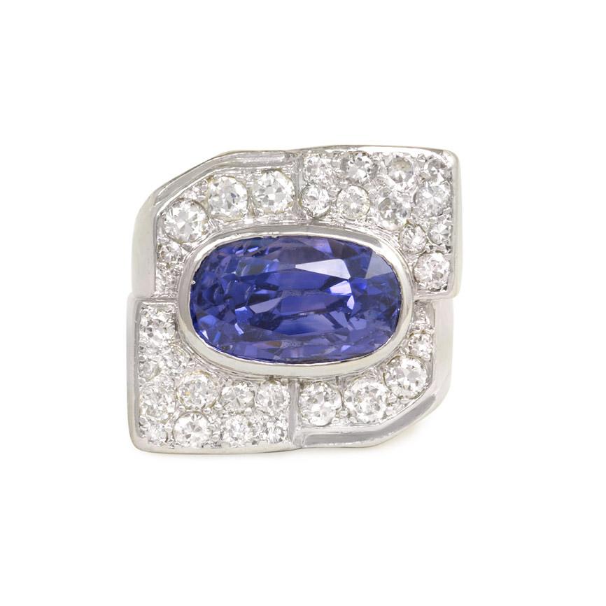 An Art Deco diamond and sapphire cocktail ring of geometric design with stepped shoulders, in platinum.  France.  Sapphire shows characteristics of being Ceylon in origin and has an approximate weight of 8.05 cts.  Atw diamonds 1.25 ct.

* Includes
