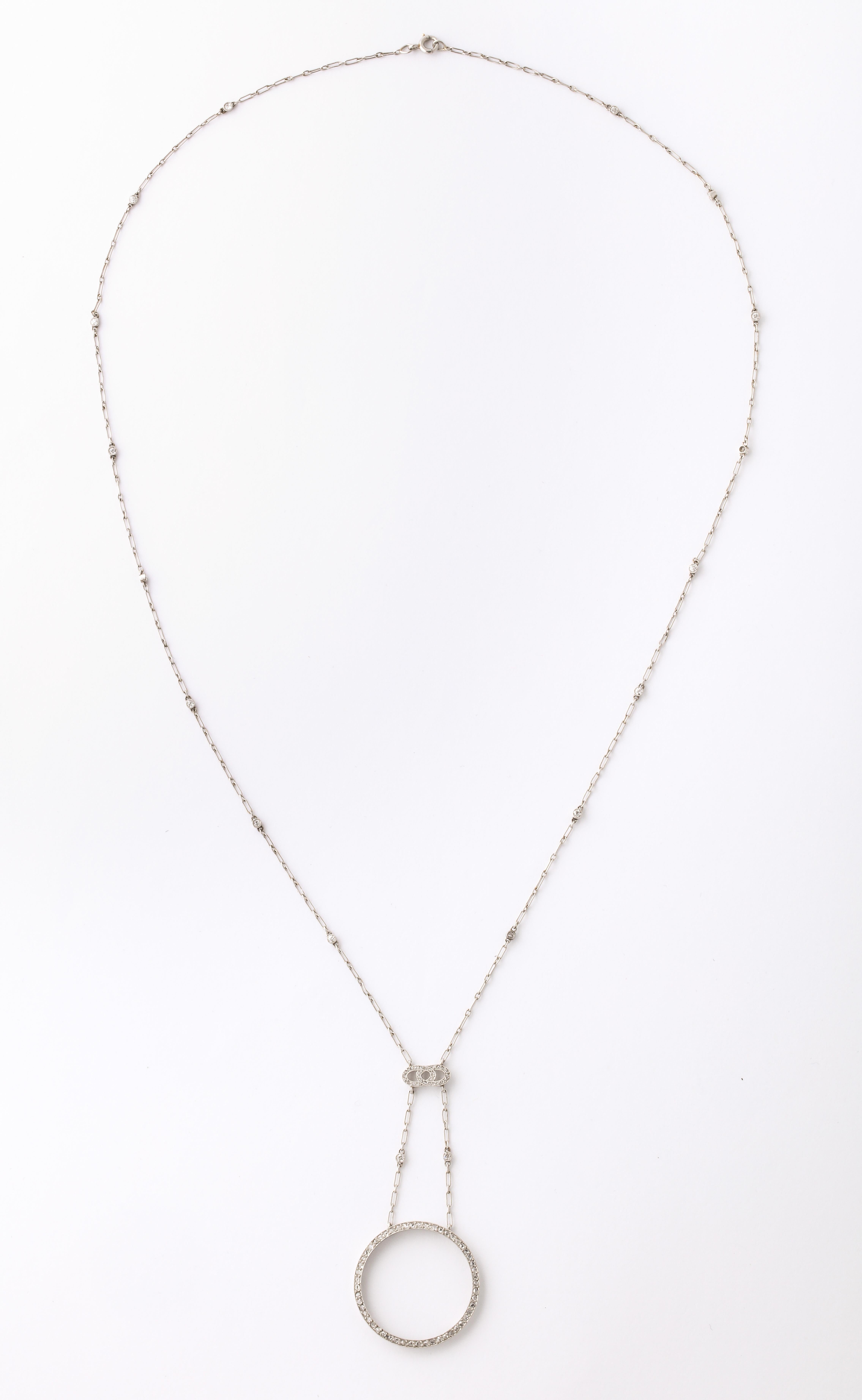 A beautiful Diamond and Platinum Necklace with a circle pendant of diamonds. The fine platinum chain has 18 diamonds interspersed  and a diamond bar attaching to
the pendant.
This is an original piece and can be worn day or night.