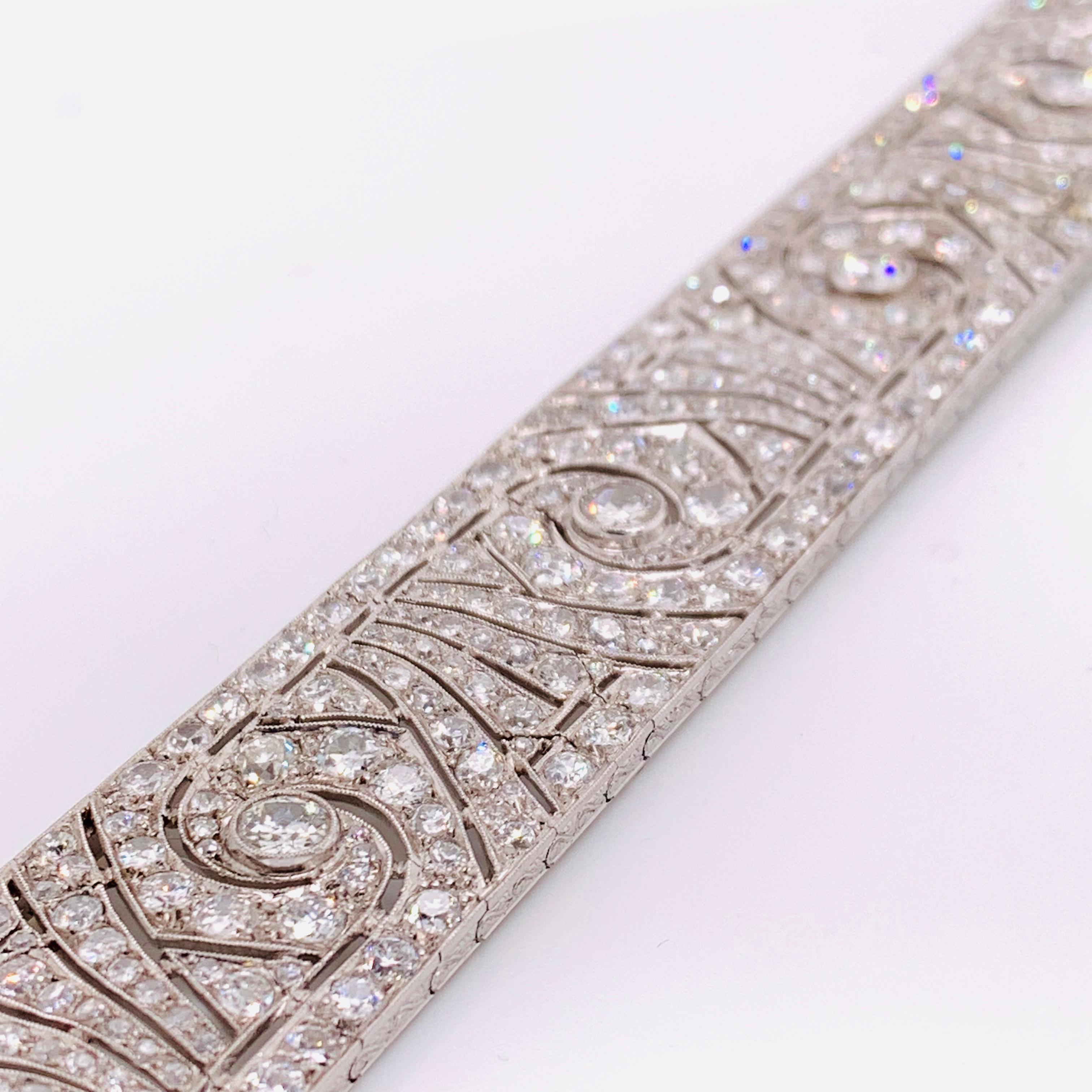 A magnificent French Art Deco diamond bracelet, set with approximately 20.00ct of old-cut diamonds. The sides are engraved with a foliate and scroll design, mounted in platinum. Circa 1930.