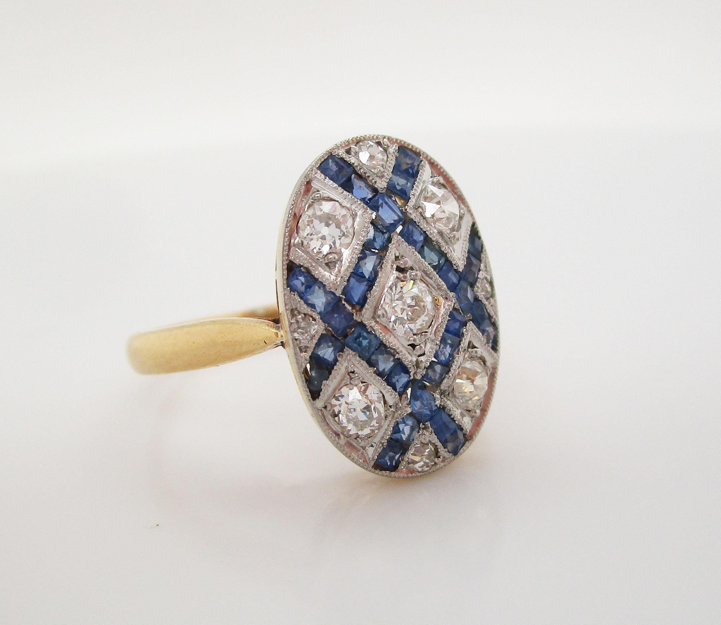 This amazing French ring is from the Art Deco movement and features a brilliant combination of white old mine cut diamonds and royal blue natural sapphires in a platinum over 18k gold setting. The stones are arranged in an incredibly intricate
