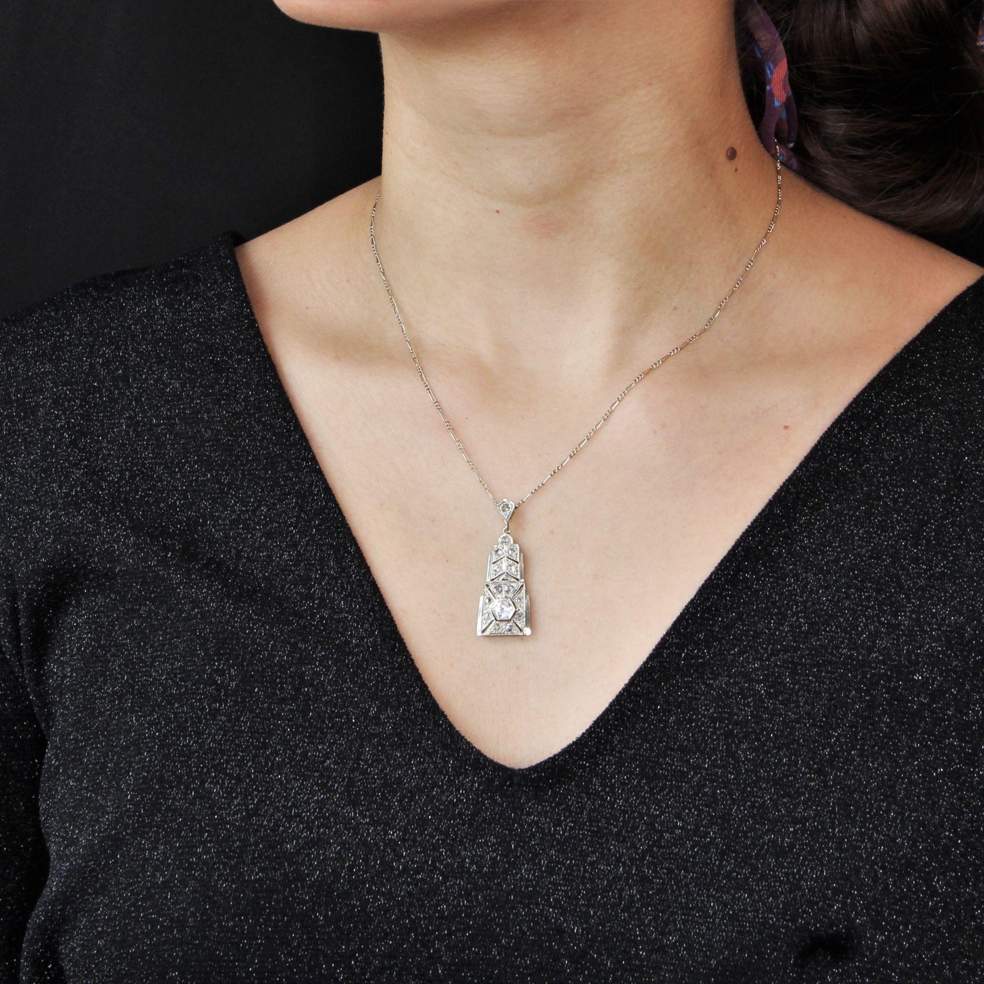Pendant in 18 karat white gold, eagle head hallmark.
Of geometrical shape, this antique pendant has an openwork decoration of grainetis set with rose- cut diamonds, the most important is an antique brilliant- cut diamond. The chain is a thin oval